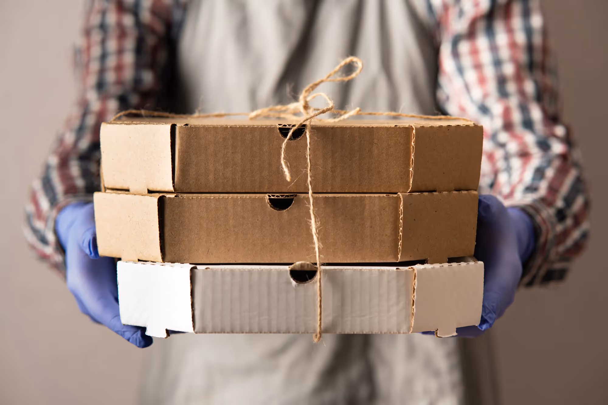 A person holding a box with a brown string around it.