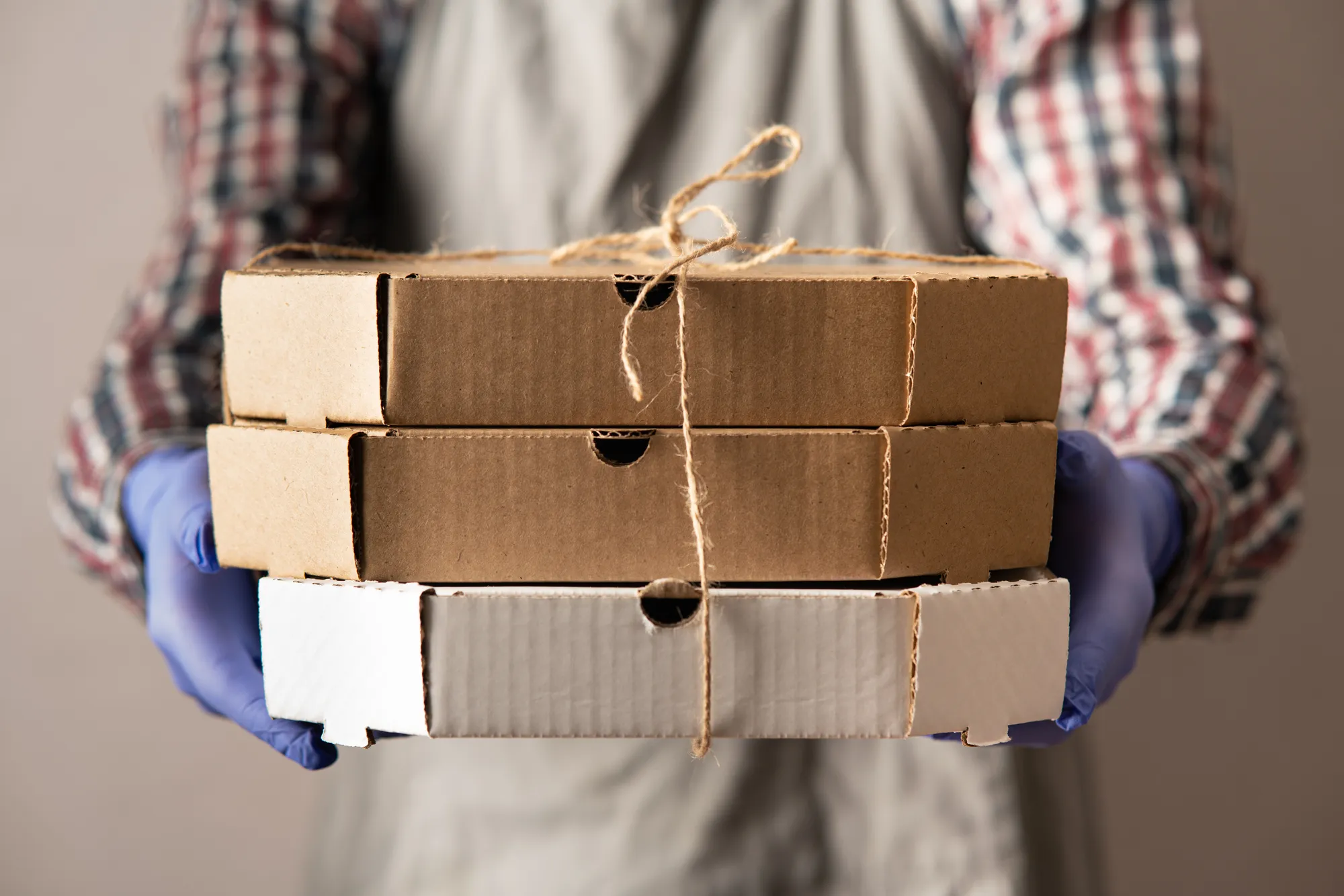 A person holding a box with a brown string around it.
