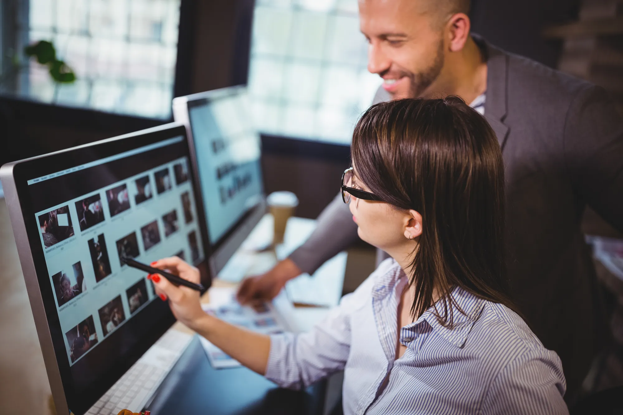 A man and woman are working on a computer.
