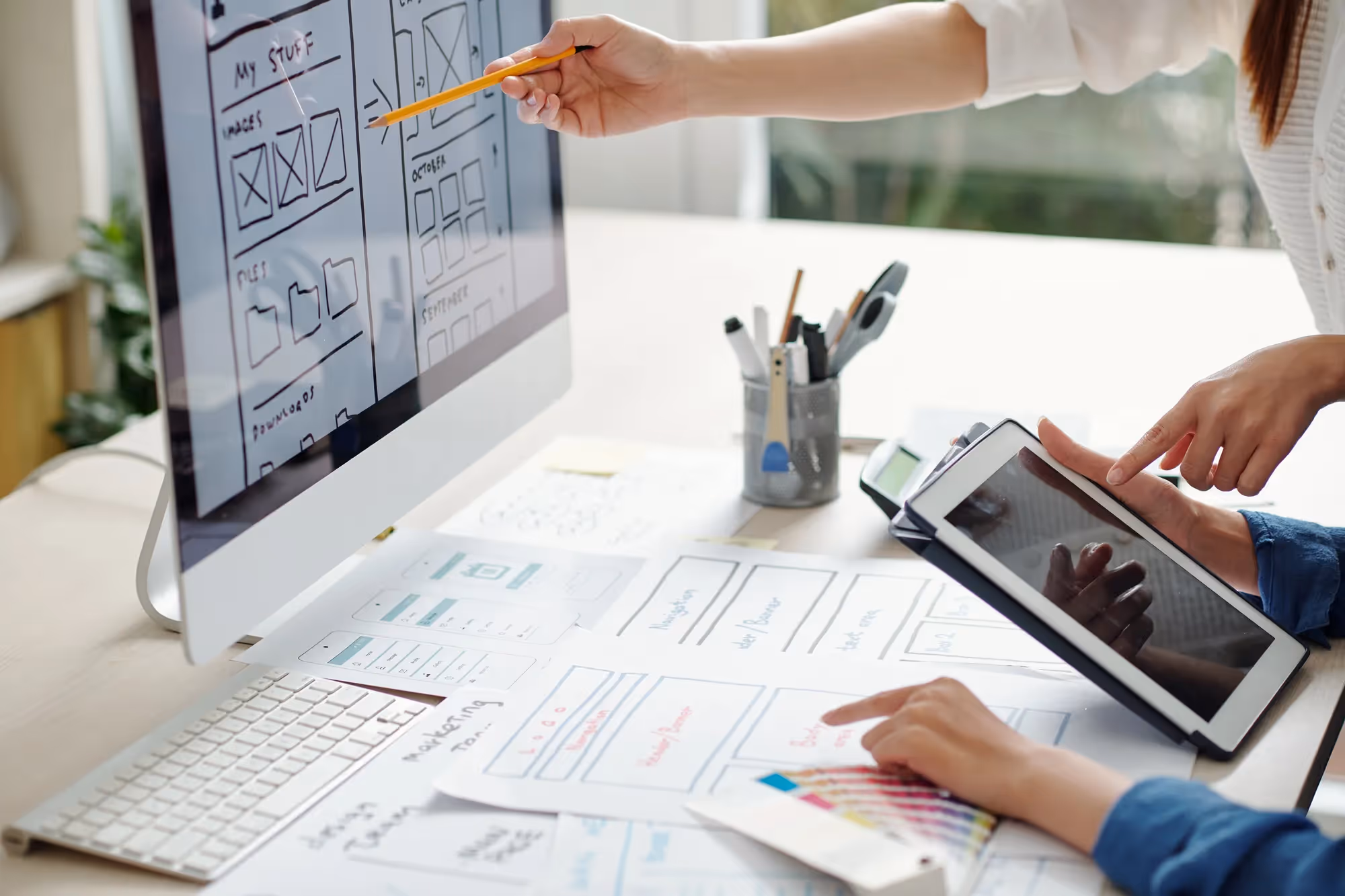 A person is using a tablet to draw on a piece of paper.