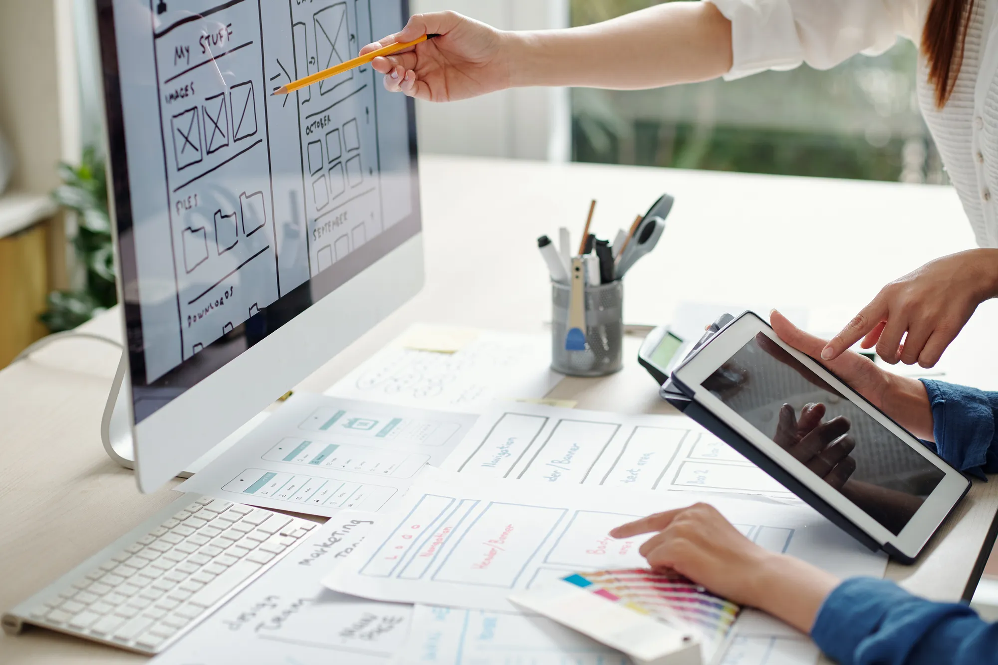 A person is using a tablet to draw on a piece of paper.