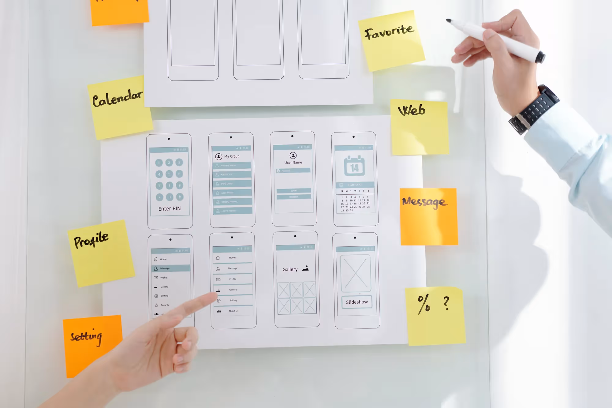 A person pointing at a whiteboard with a list of words on it.