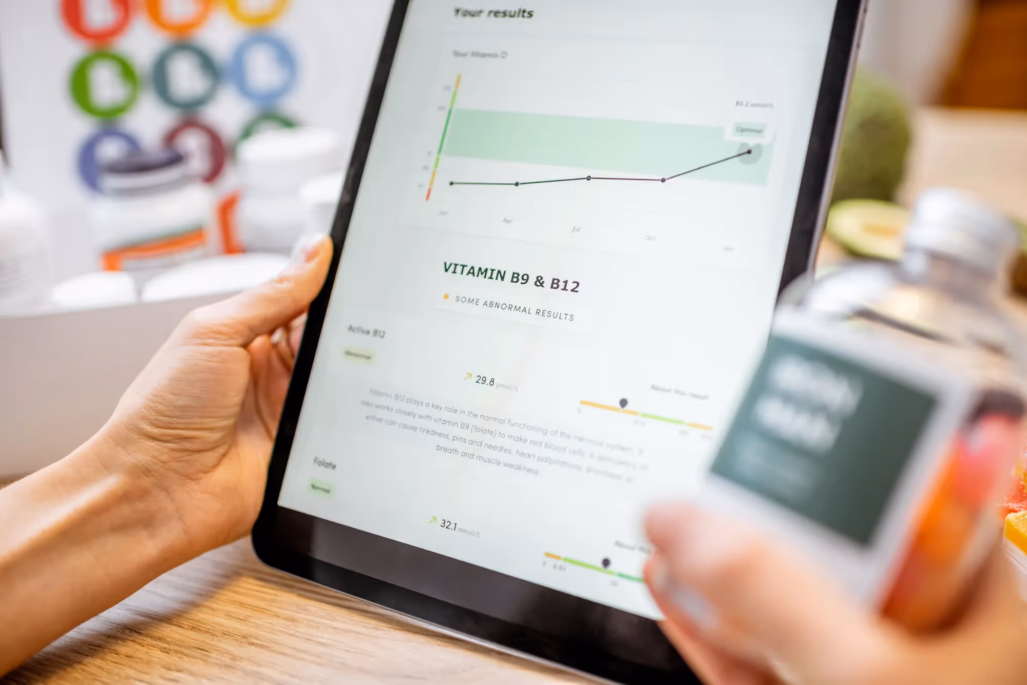 A person holding a tablet with a vitamin and mineral tracker on the screen.
