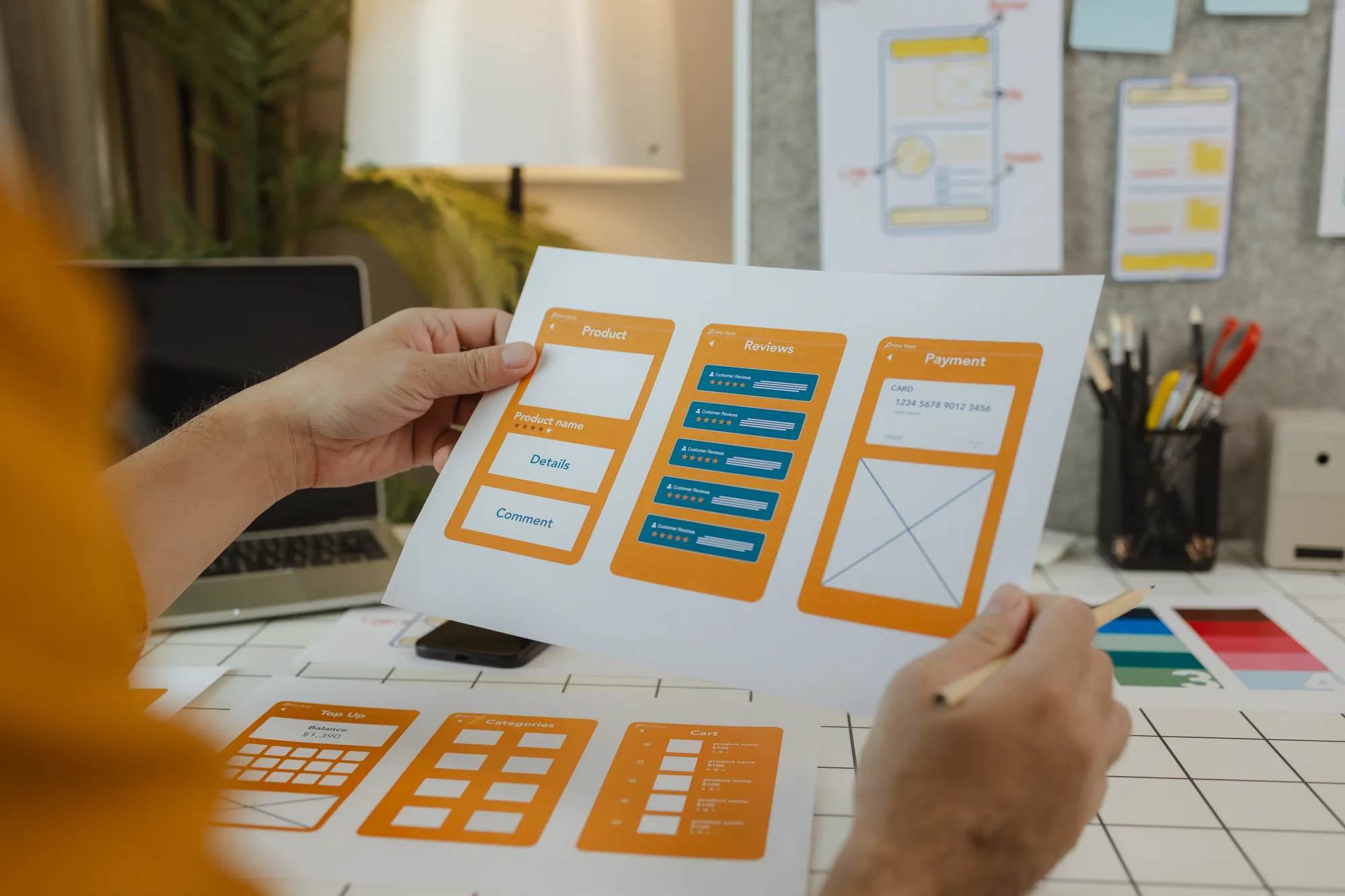 A person holding a piece of paper with a website design on it.
