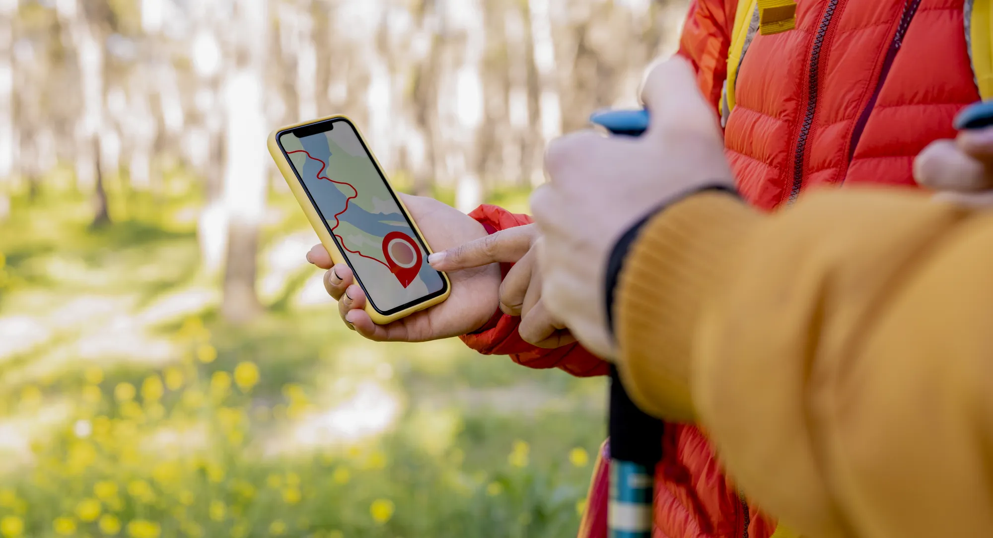 A person holding a cell phone with a map on the screen.
