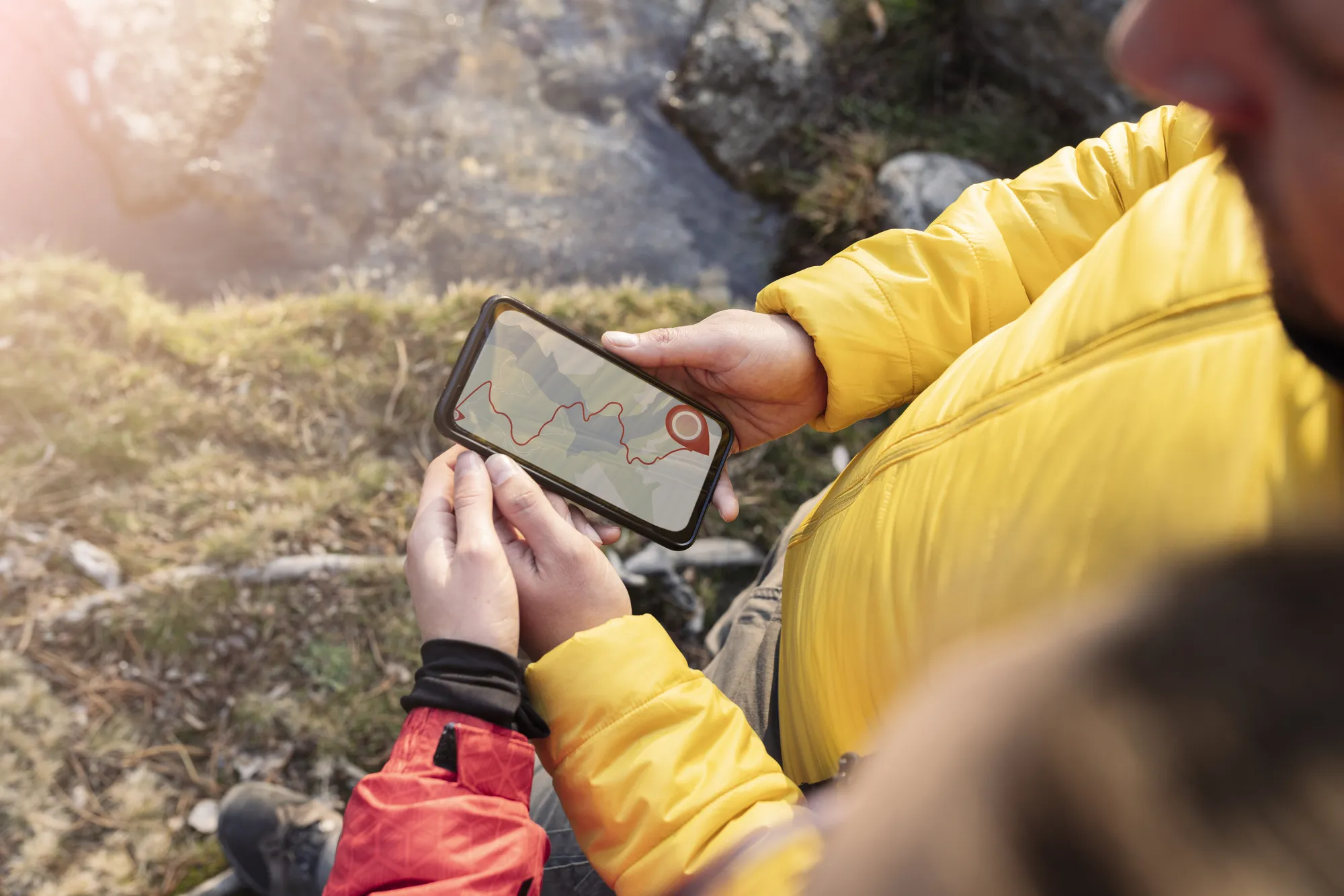 A man holding a cell phone with a map on the screen.