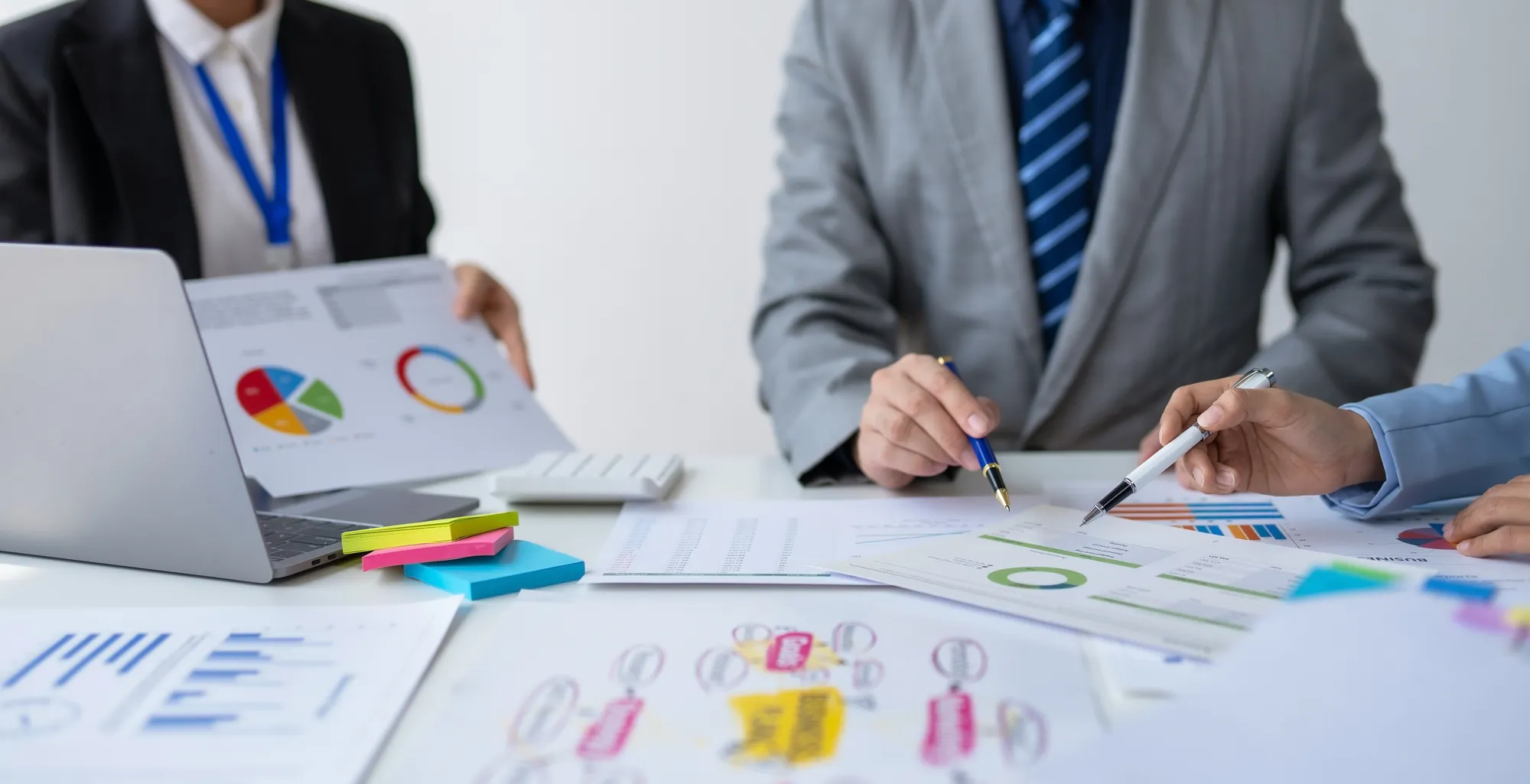 A man in a suit is writing on a piece of paper.