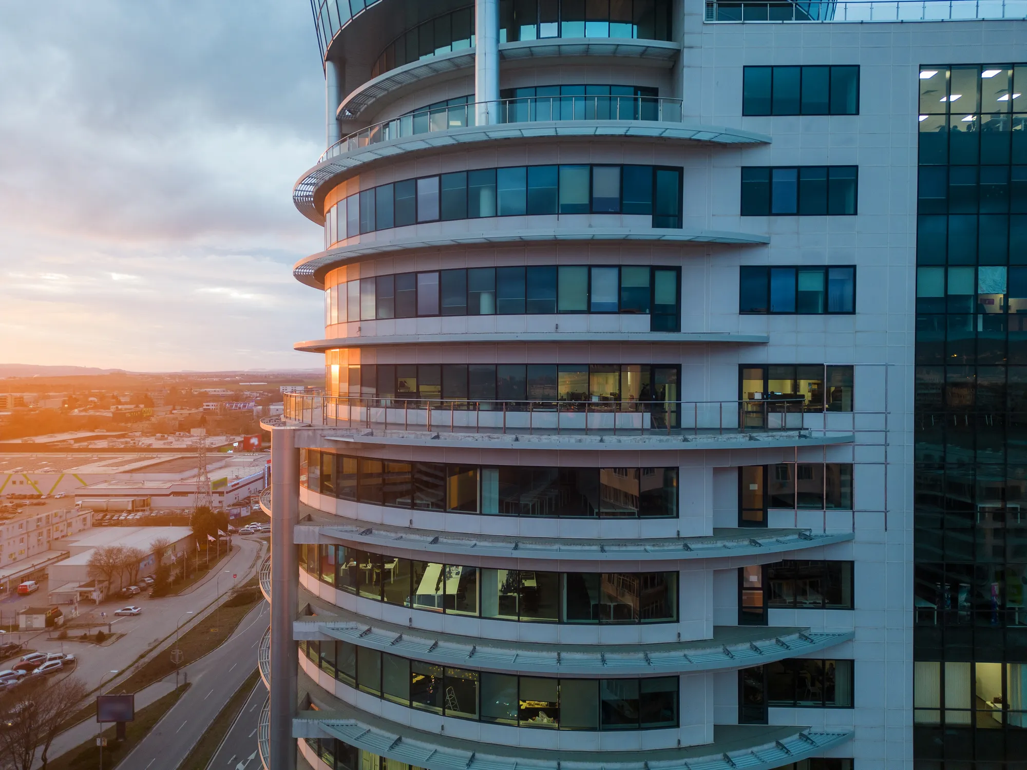 A tall building with a glass exterior and a large round window.