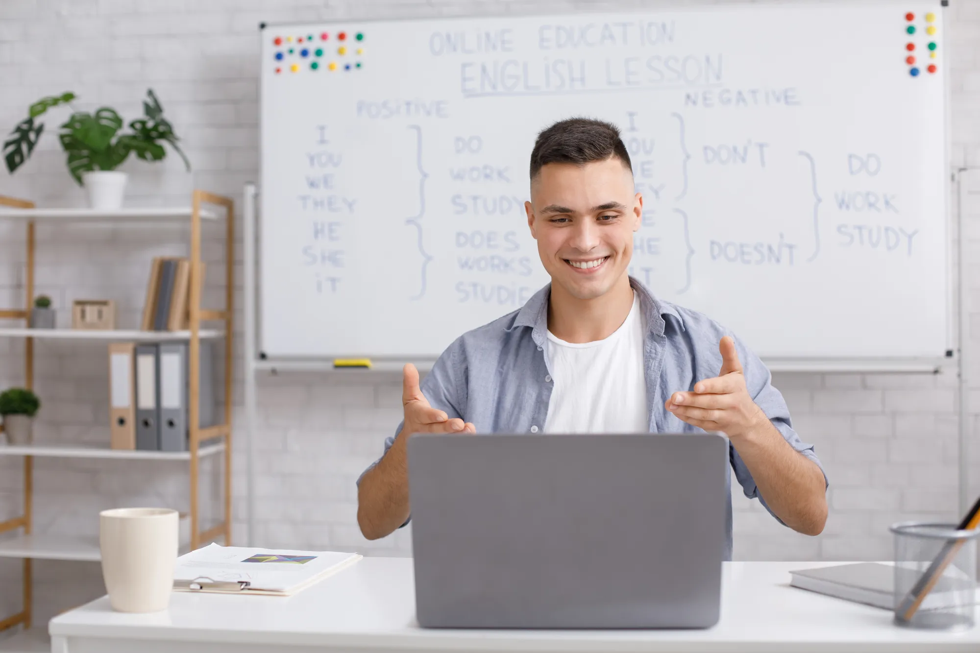 A man is smiling while using a laptop.