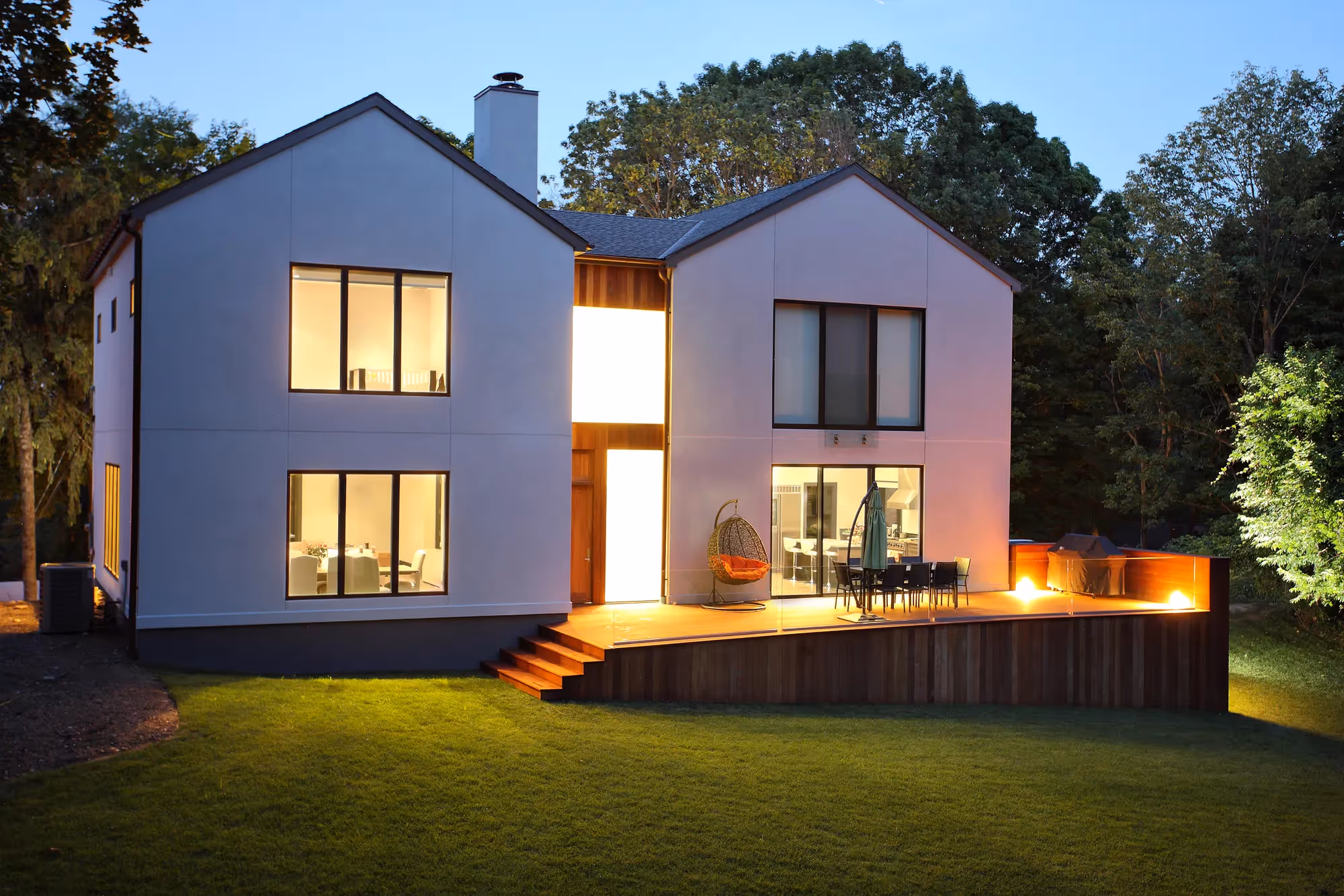 A large white house with a fire pit in the backyard.