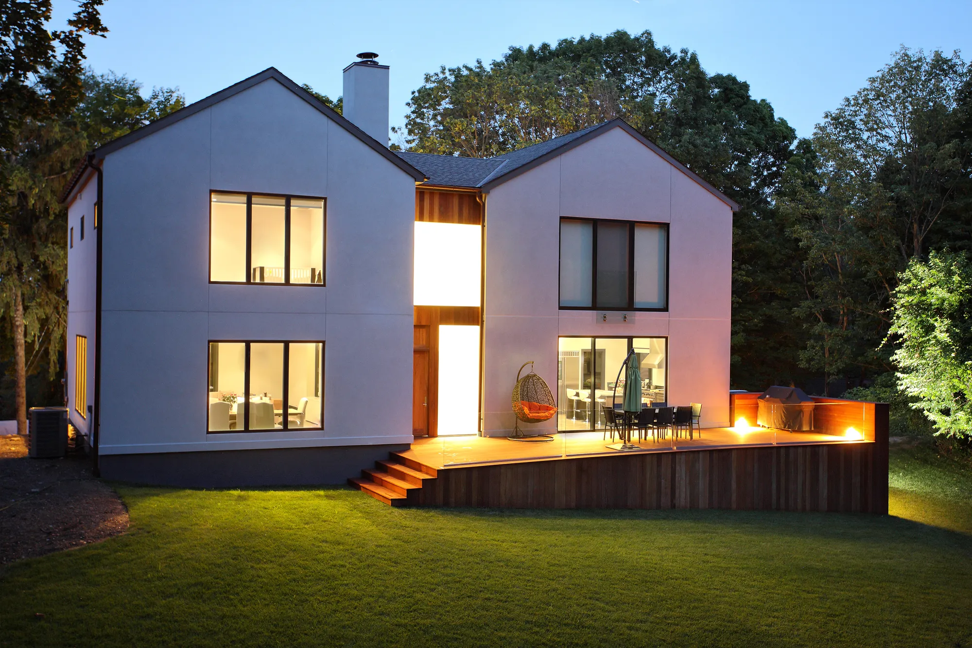 A large white house with a fire pit in the backyard.