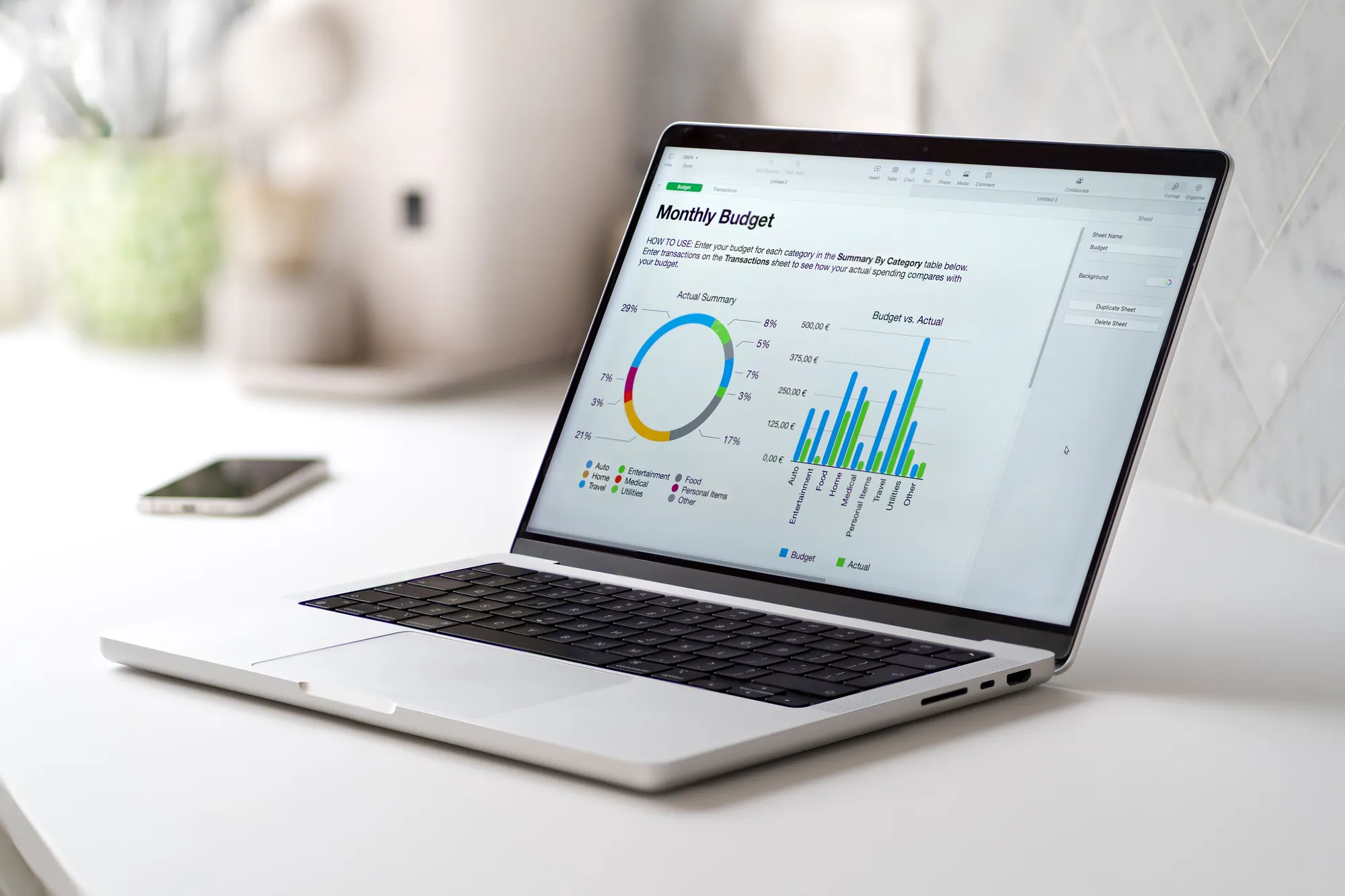 A laptop with a screen displaying a budget spreadsheet.