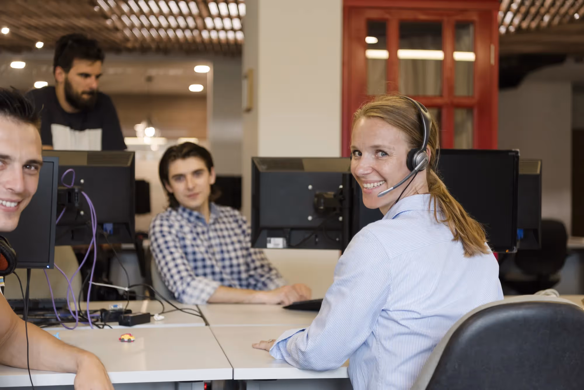 A woman wearing a headset is smiling at the camera.