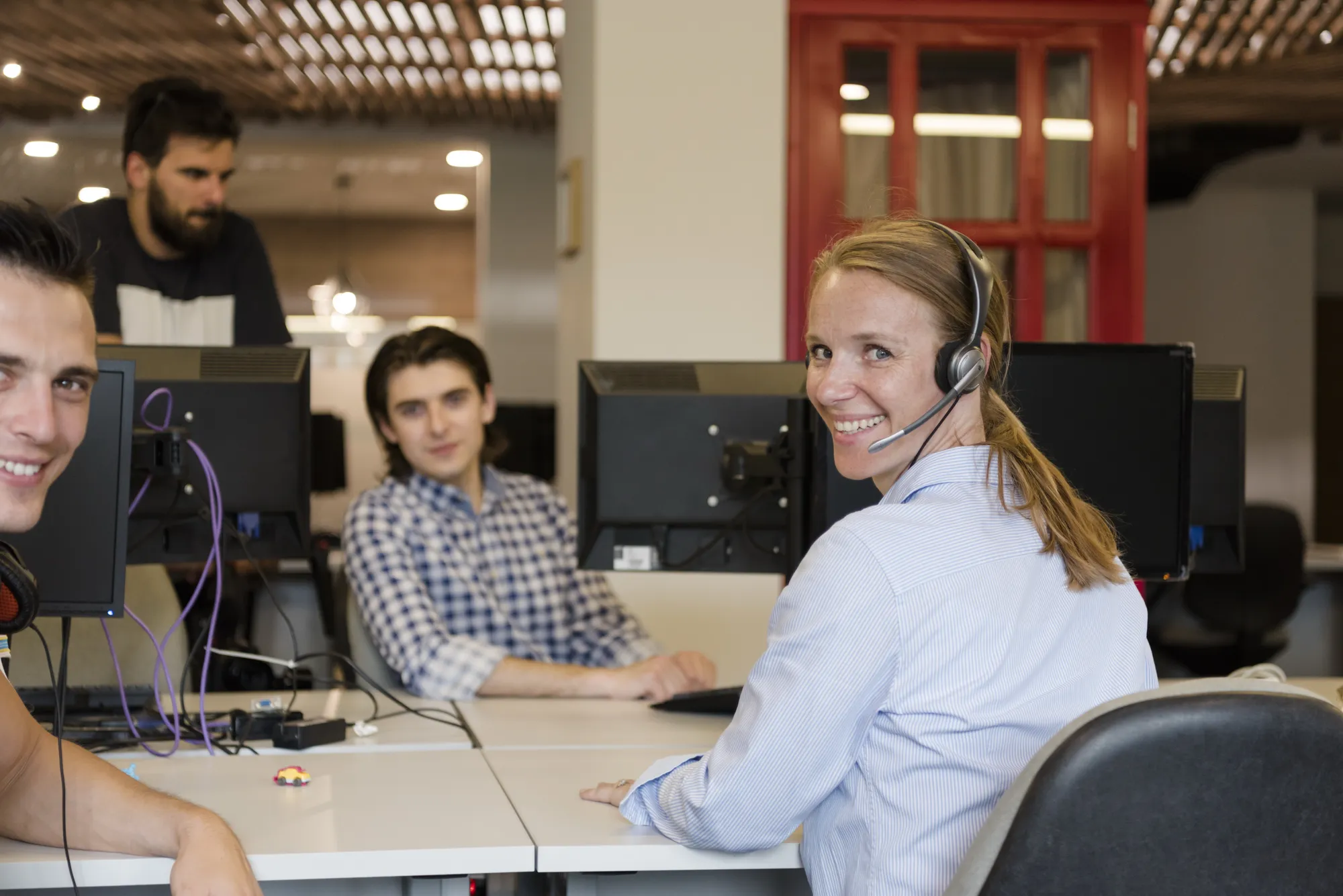 A woman wearing a headset is smiling at the camera.