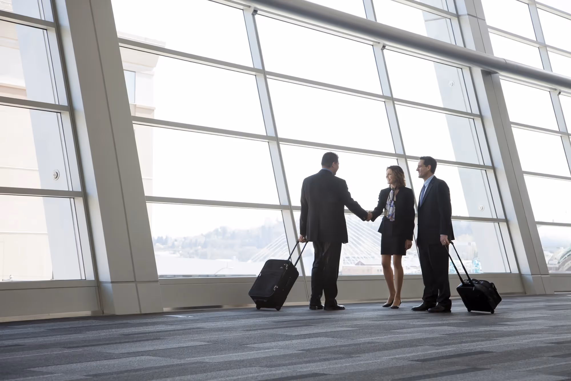 A group of people standing in a lobby with luggage.