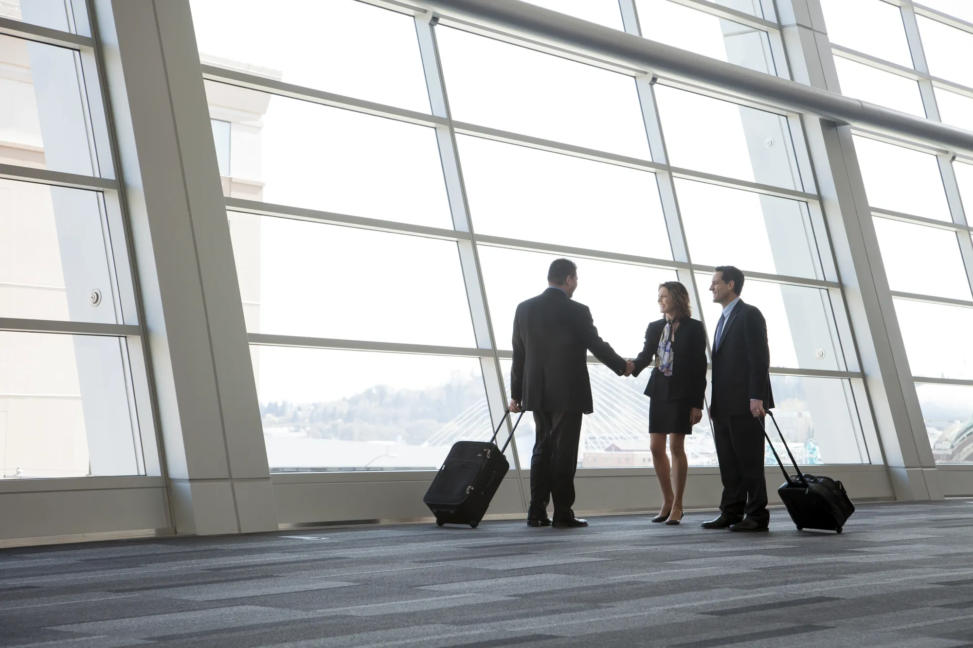A group of people standing in a lobby with luggage.