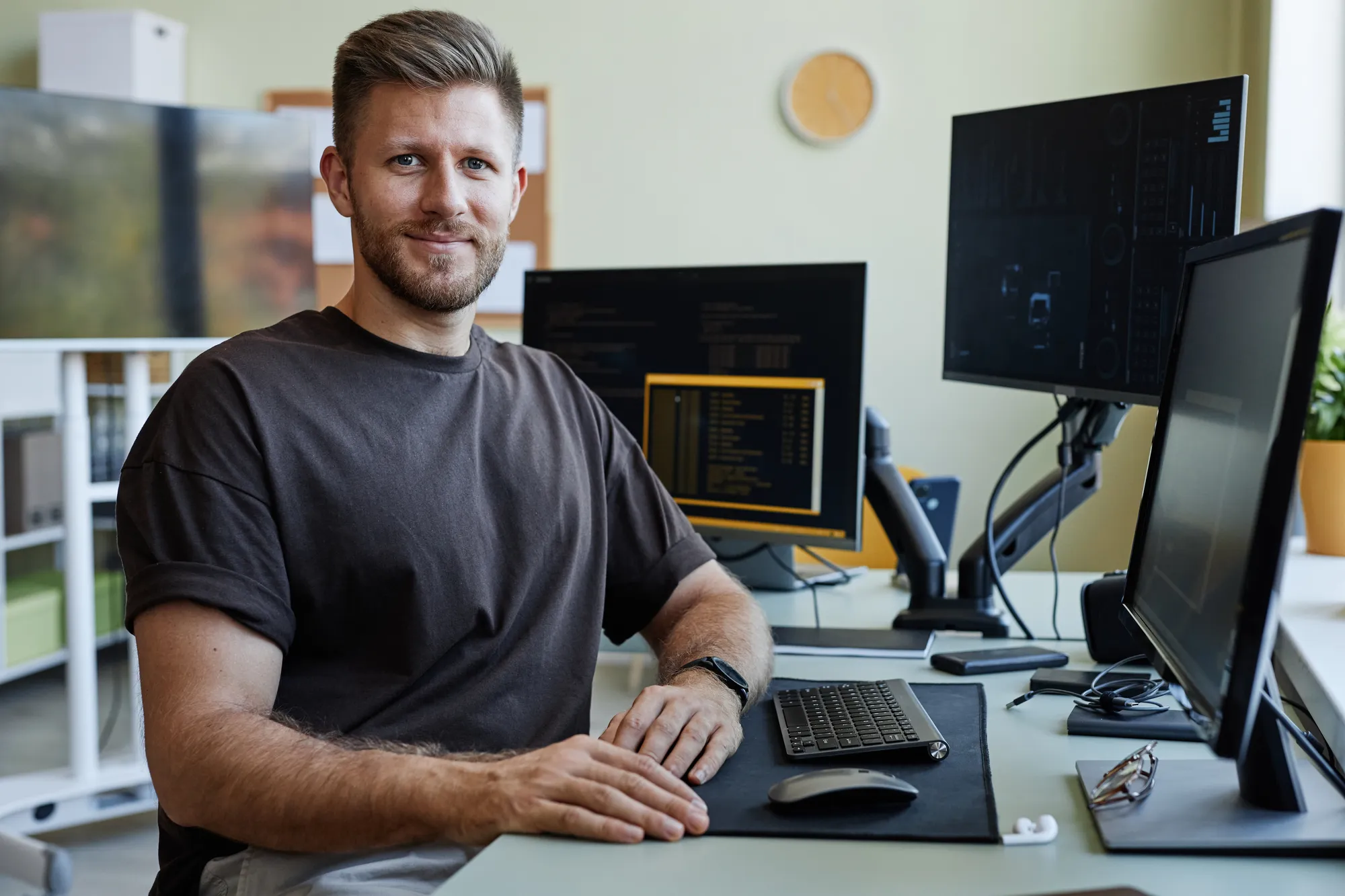 A man sitting at a desk with a computer monitor and keyboard.