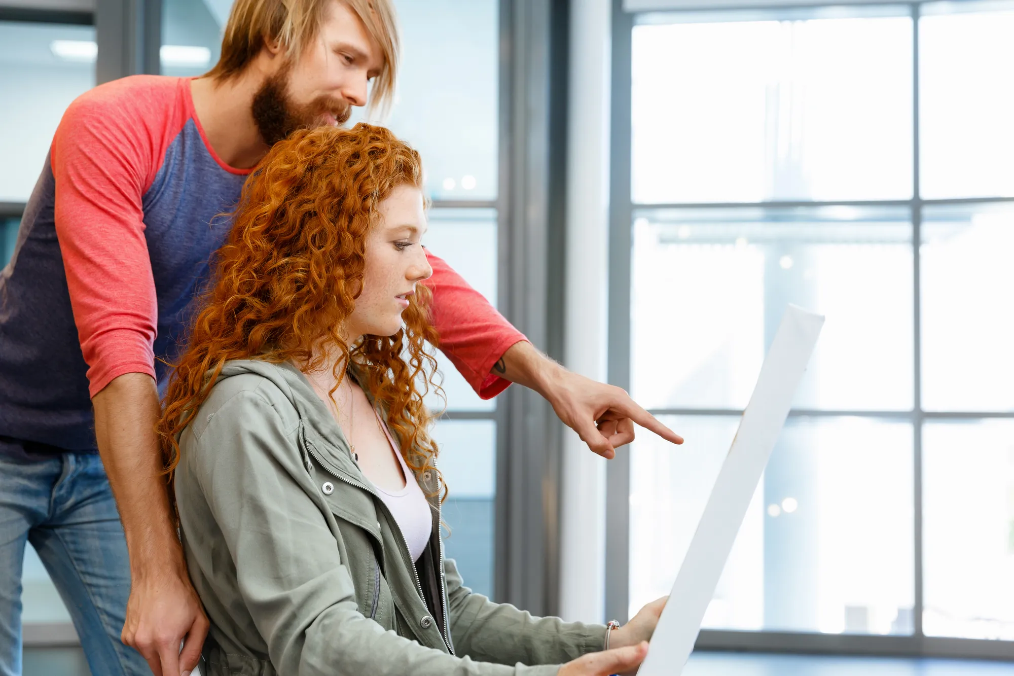 A man and woman looking at a paper together.