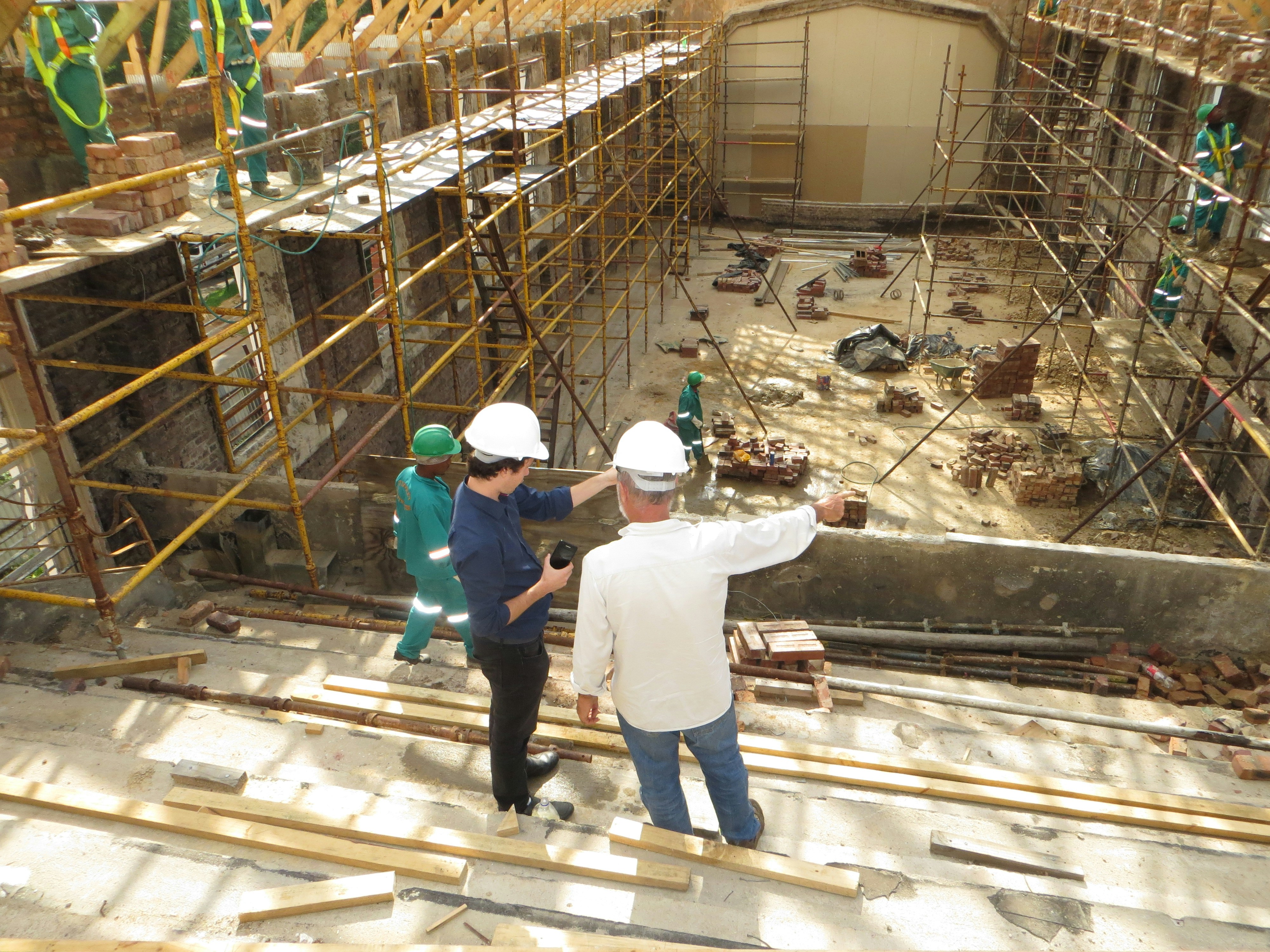 Two men standing on a construction site talking.
