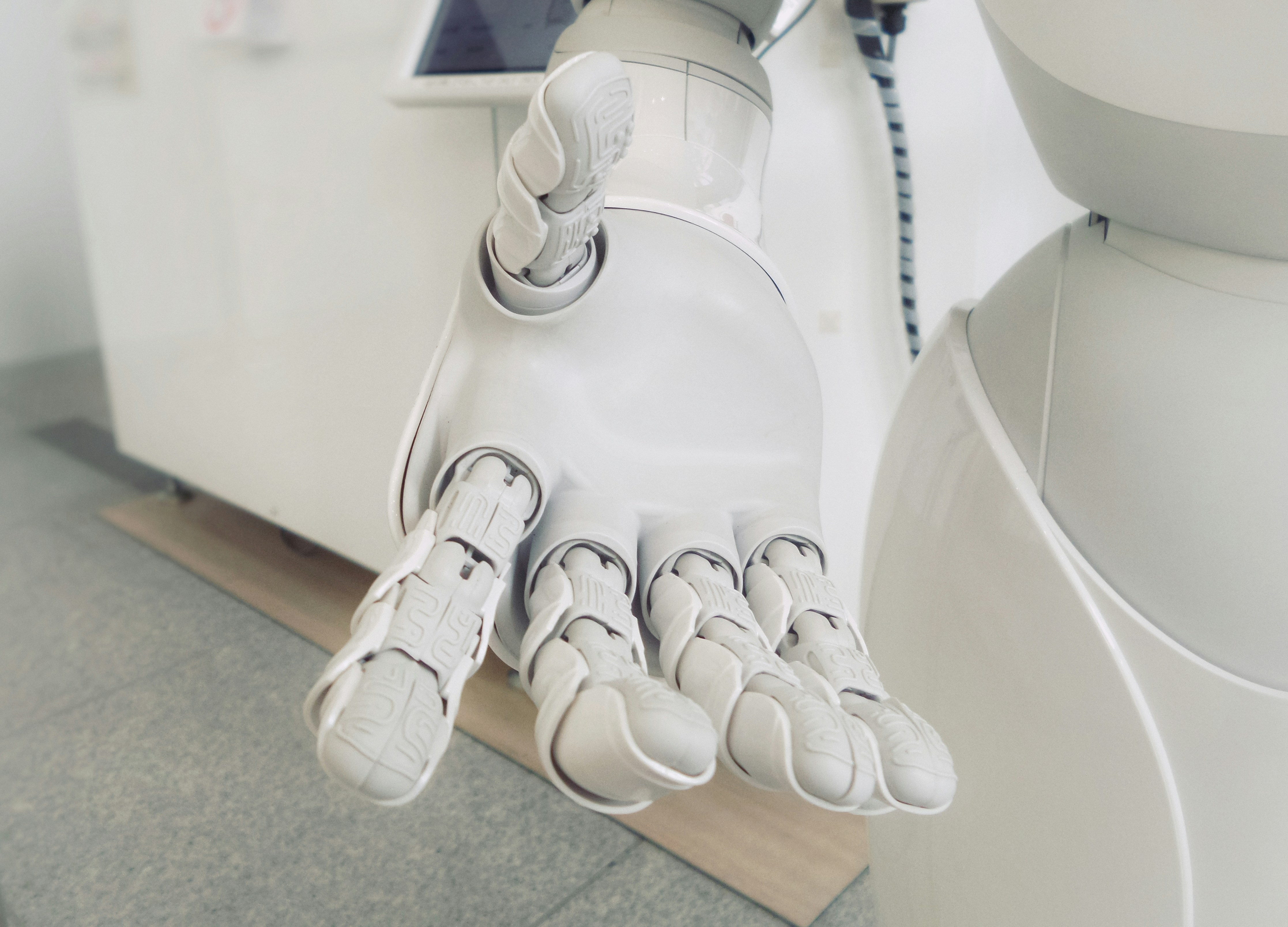 A robotic hand with a white glove on it.