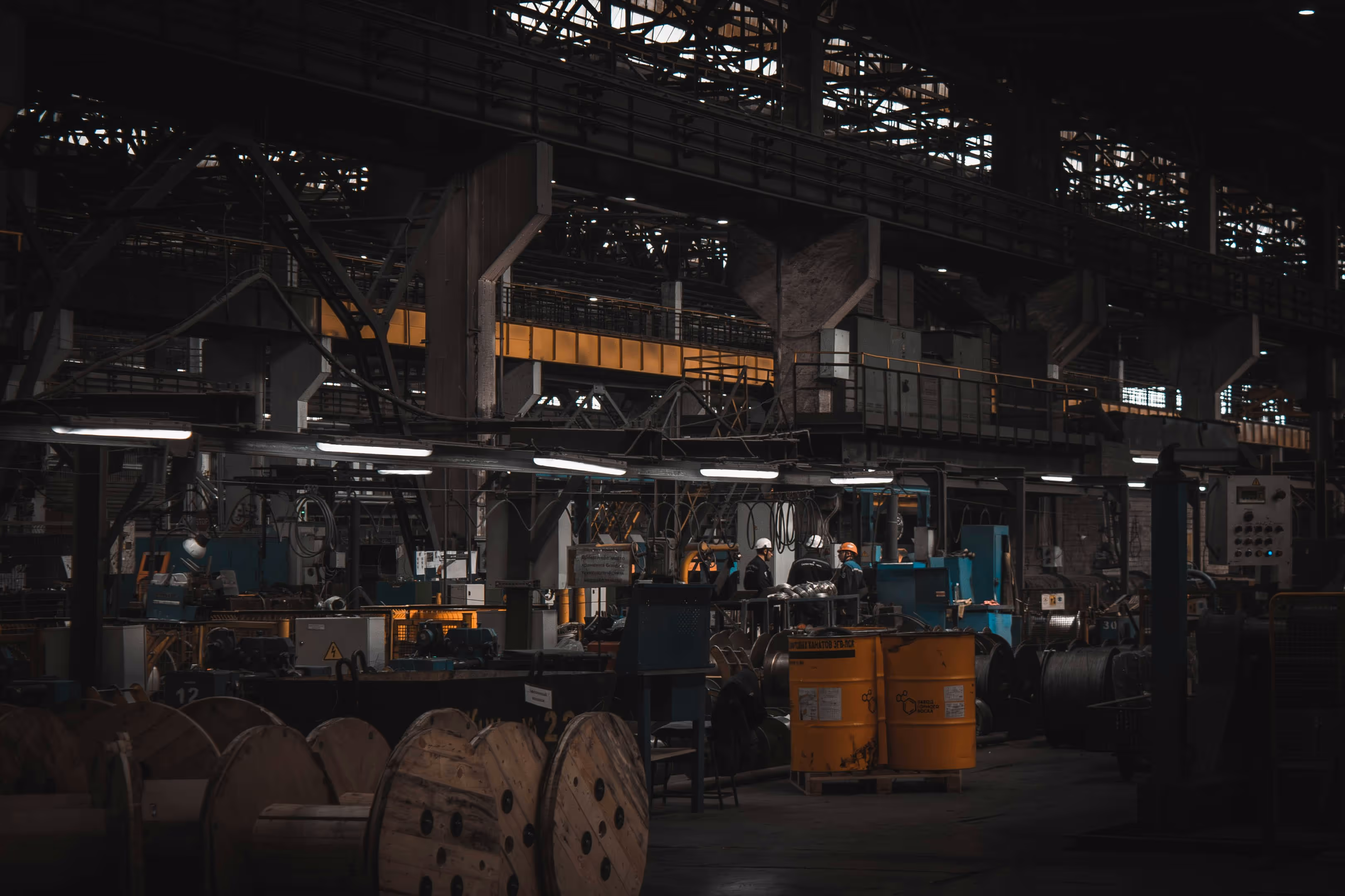 A factory with a large metal structure and a man in a hard hat.