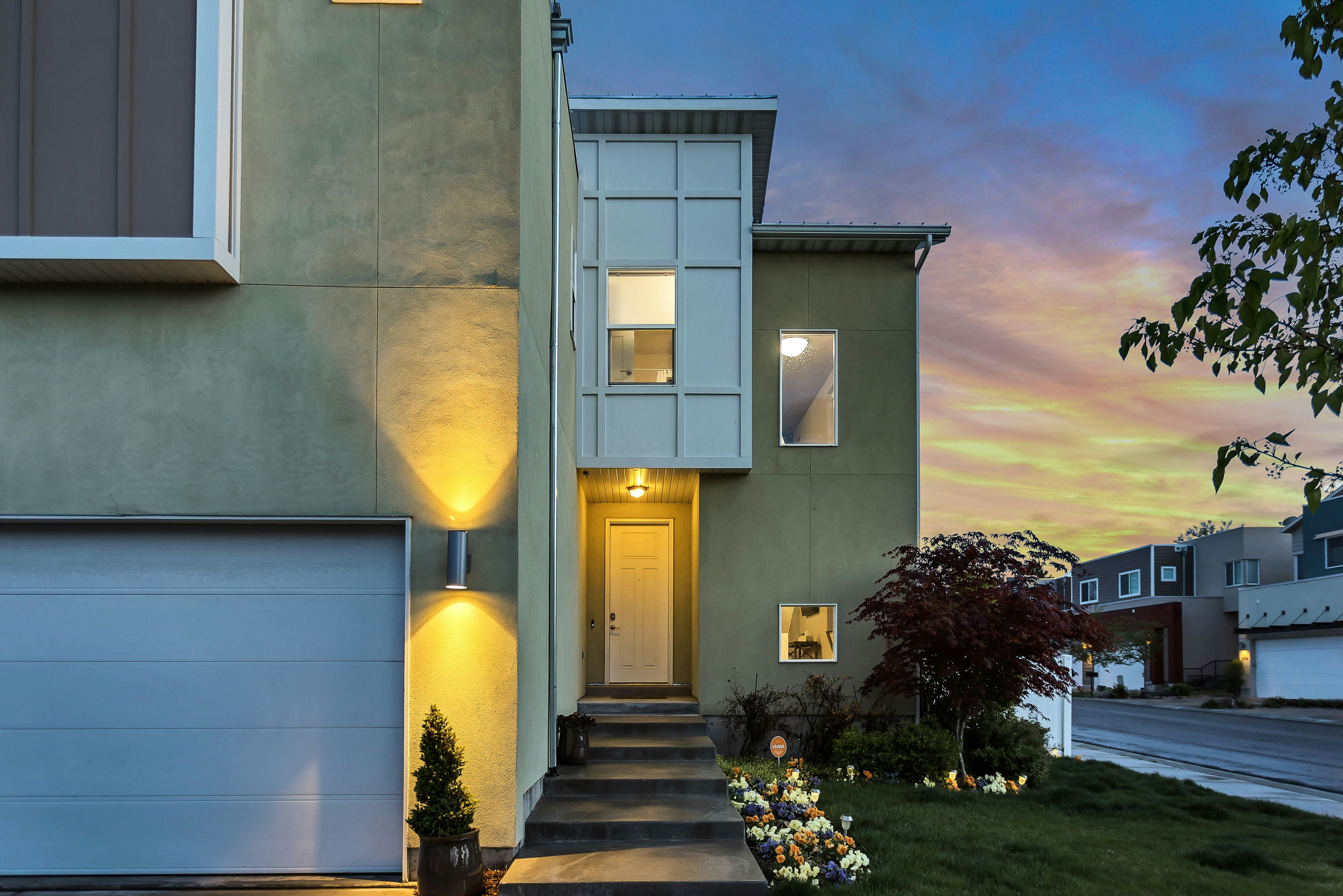A house with a white door and a green garage.