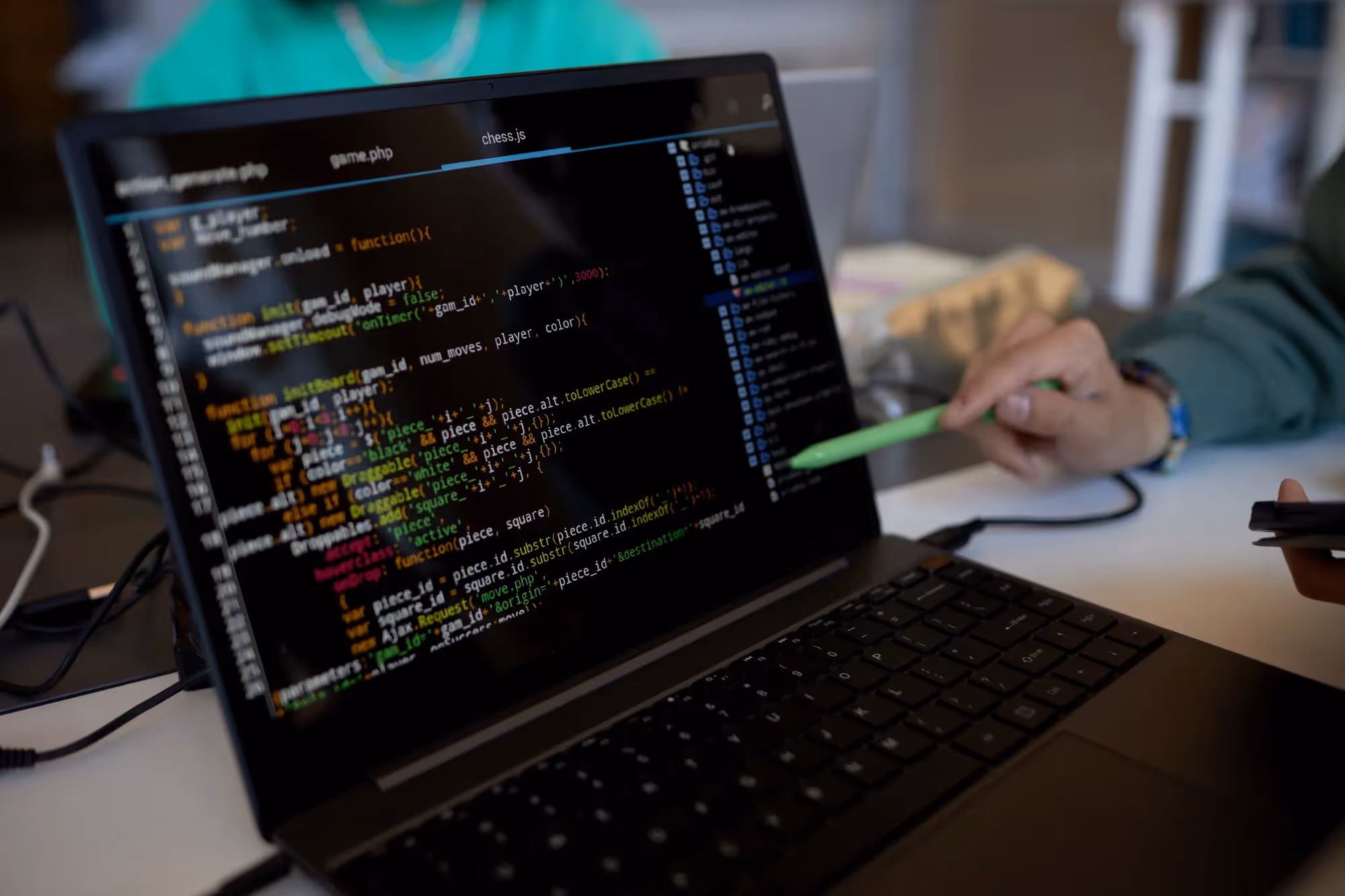 A laptop with a green pen on the keyboard.