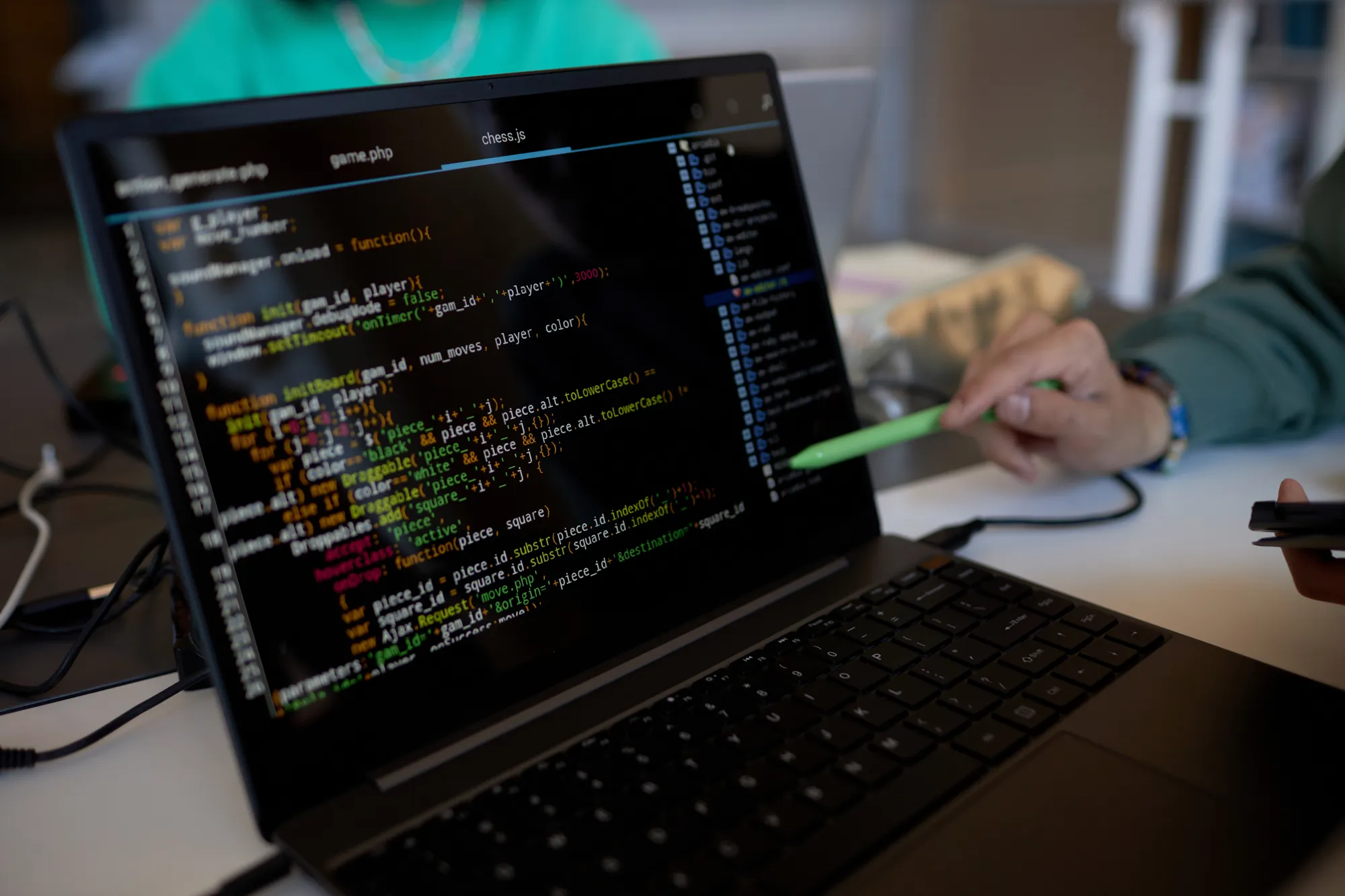 A laptop with a green pen on the keyboard.