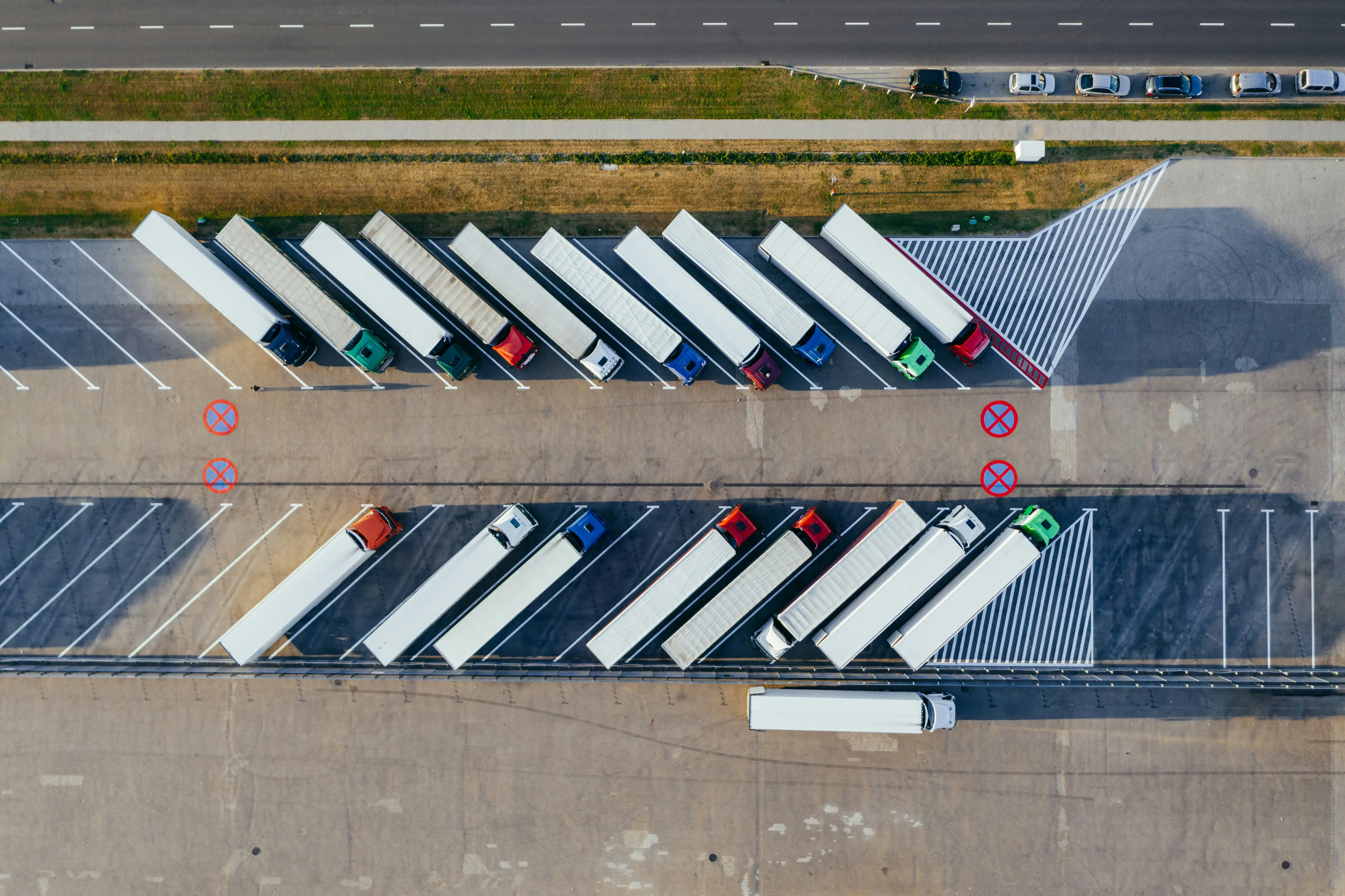 A parking lot with a row of trucks parked in it.
