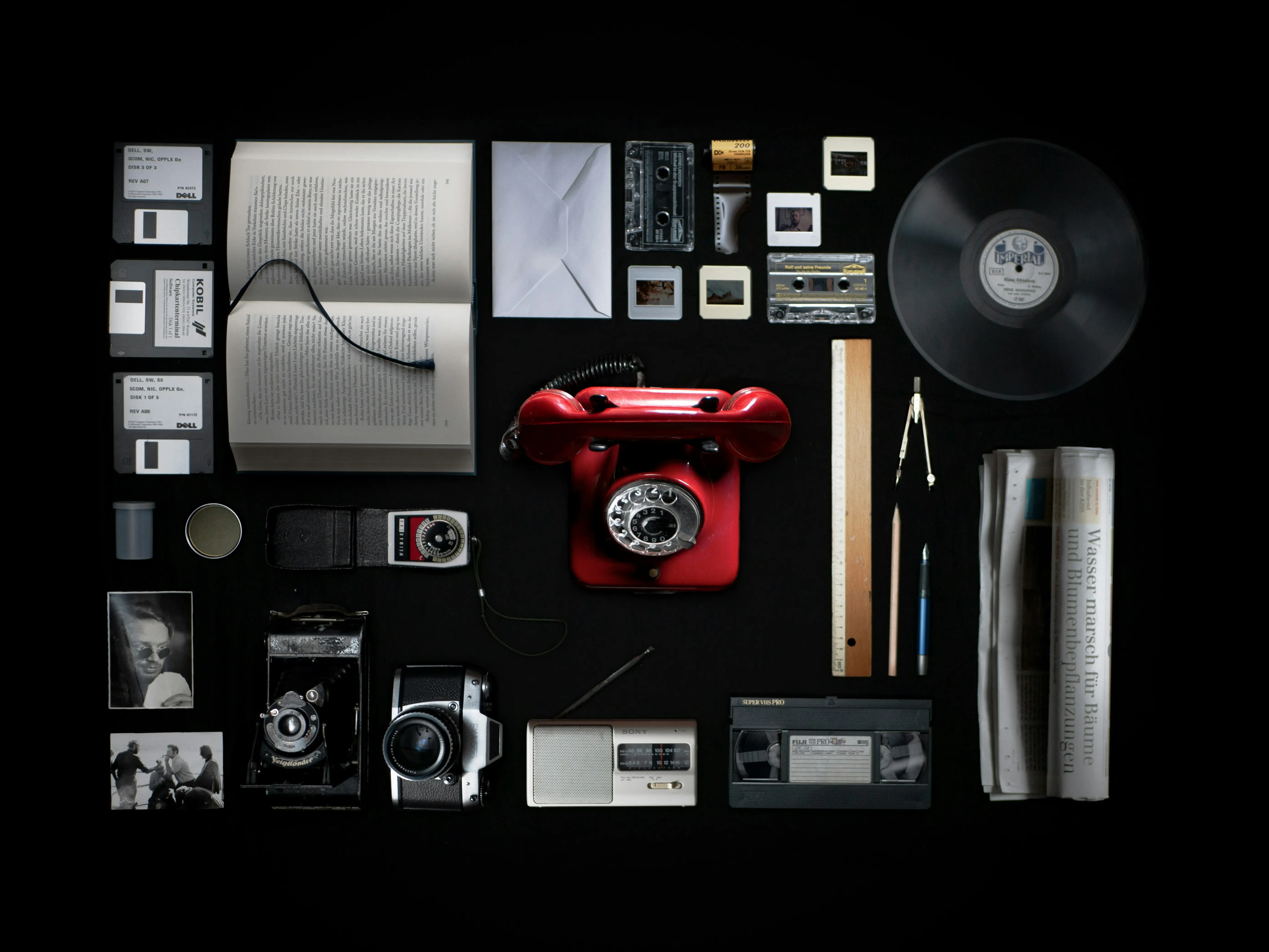 A collection of old school items including a red phone and a camera.