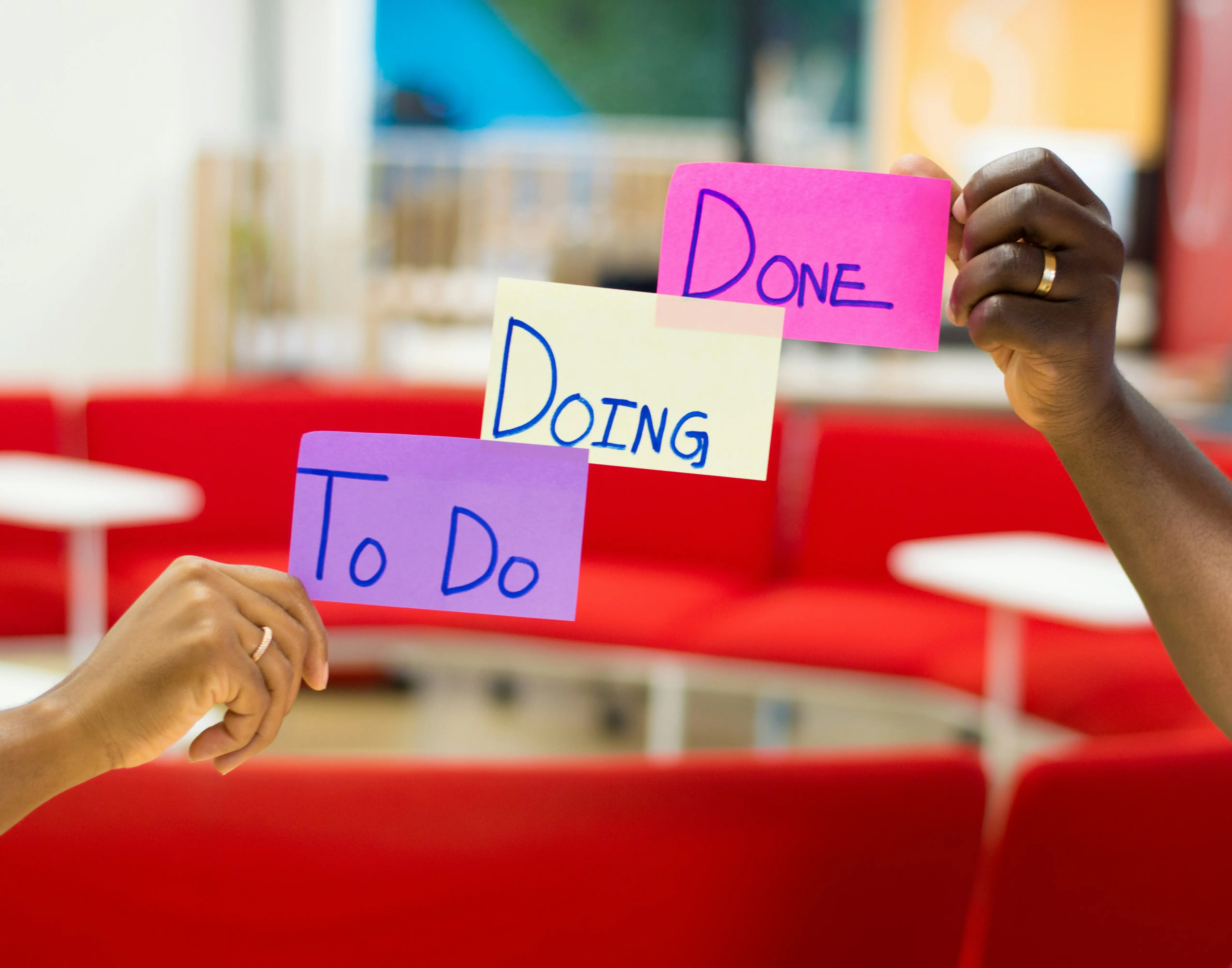 Two people holding up signs that say "Doing to do".