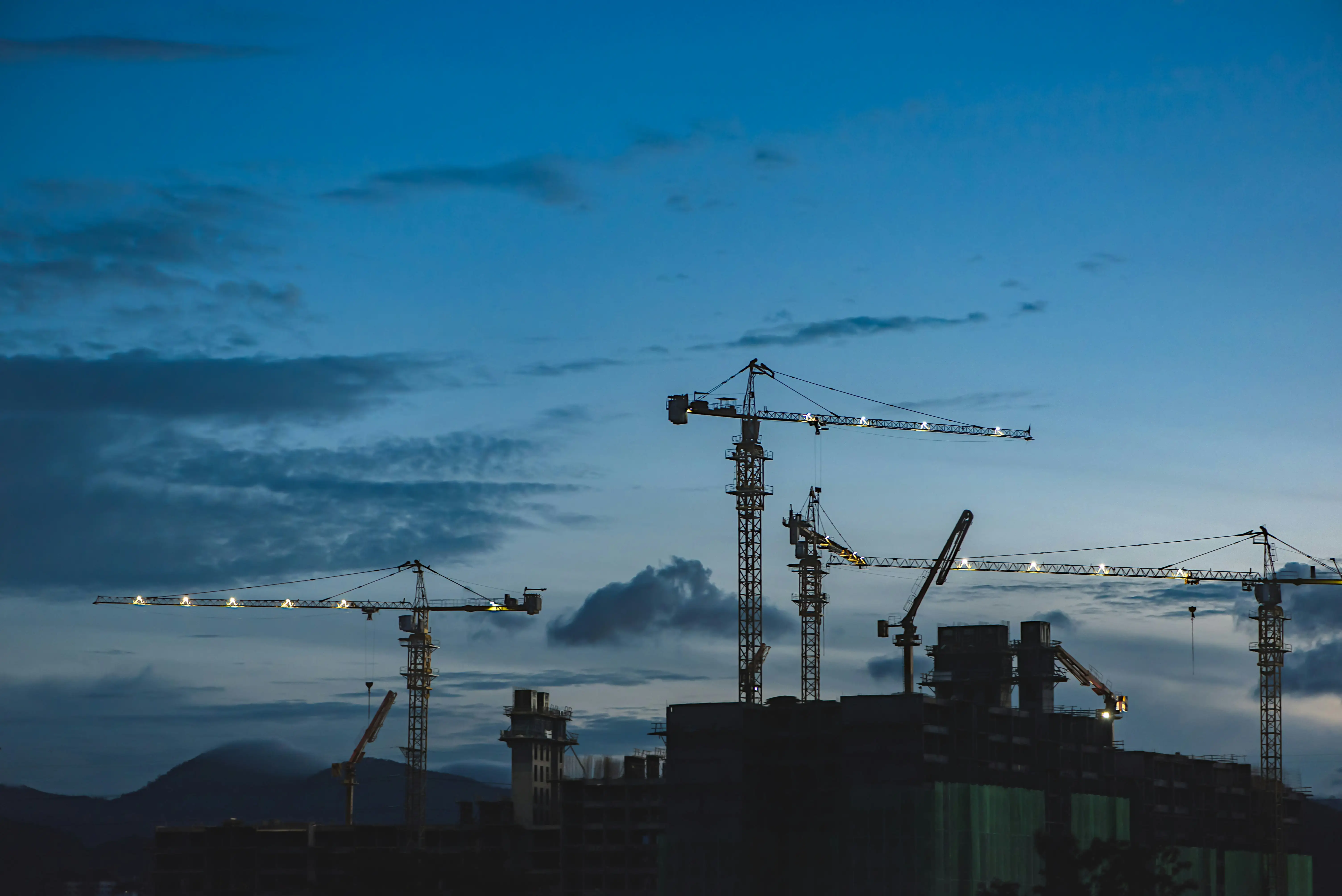 A large crane is lit up at night.