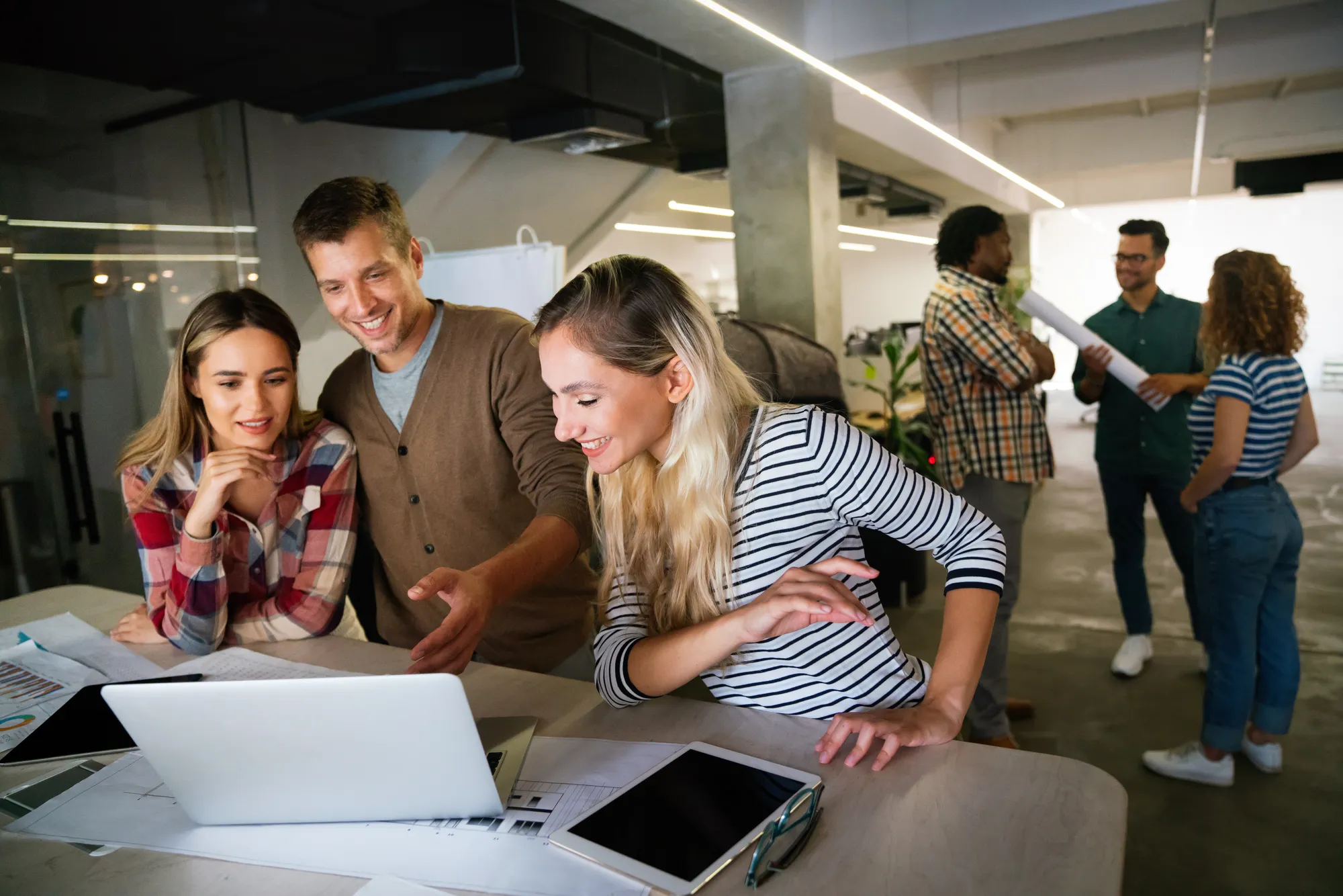 A group of people looking at a laptop.