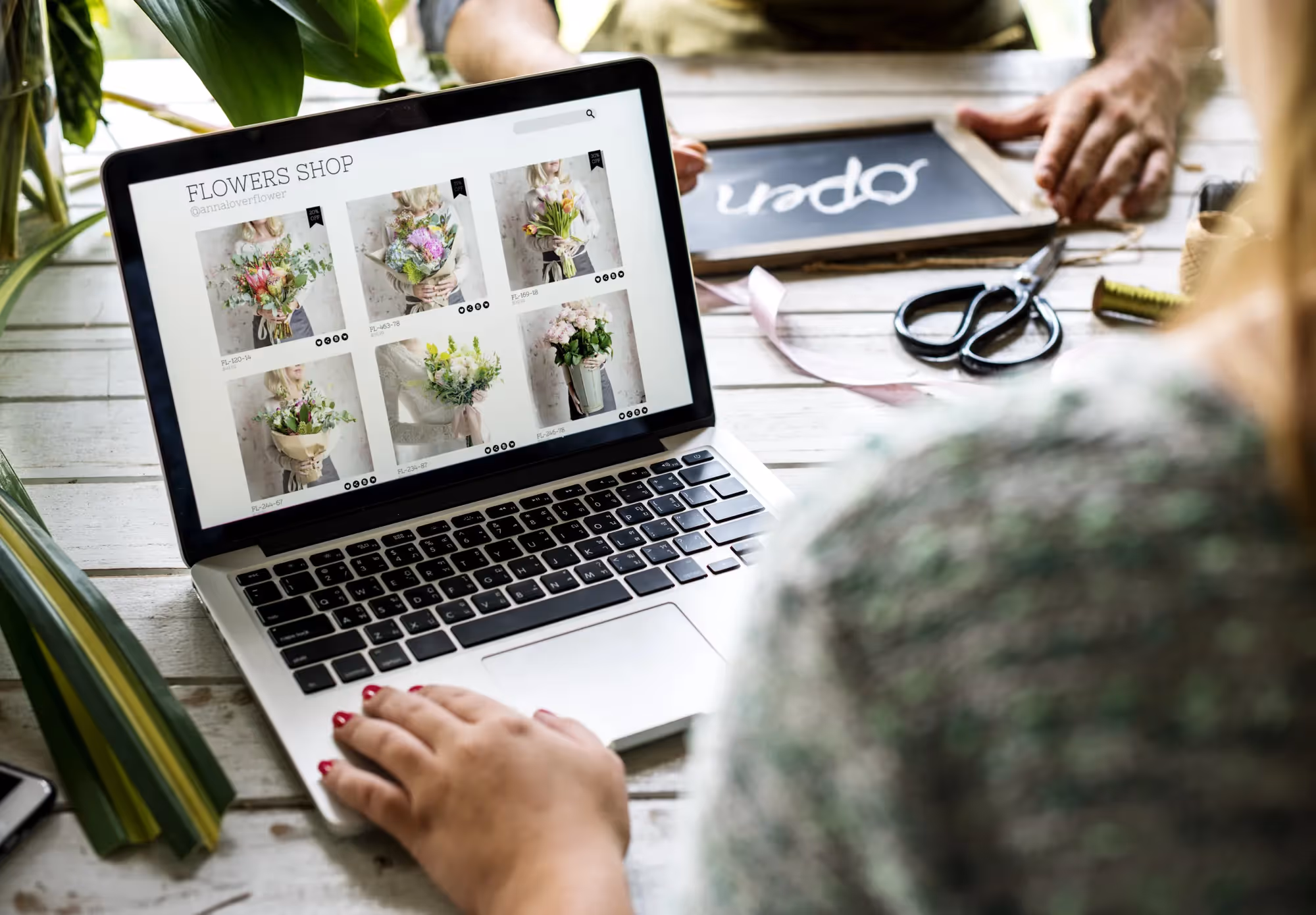 A person is using a laptop to view a website about flowers.