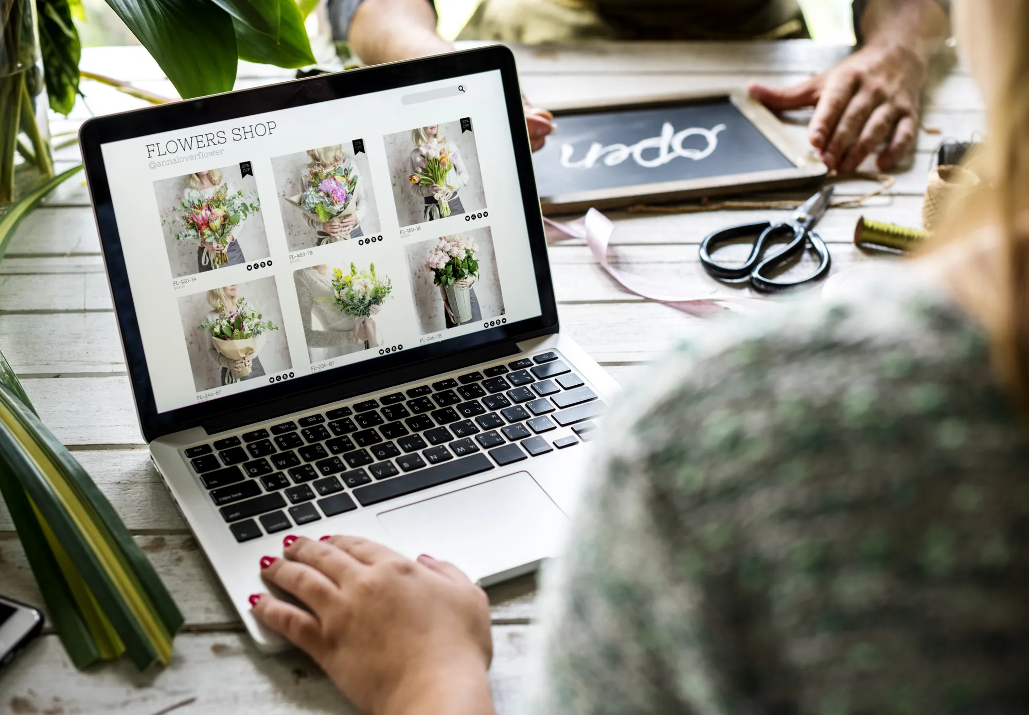 A person is using a laptop to view a website about flowers.