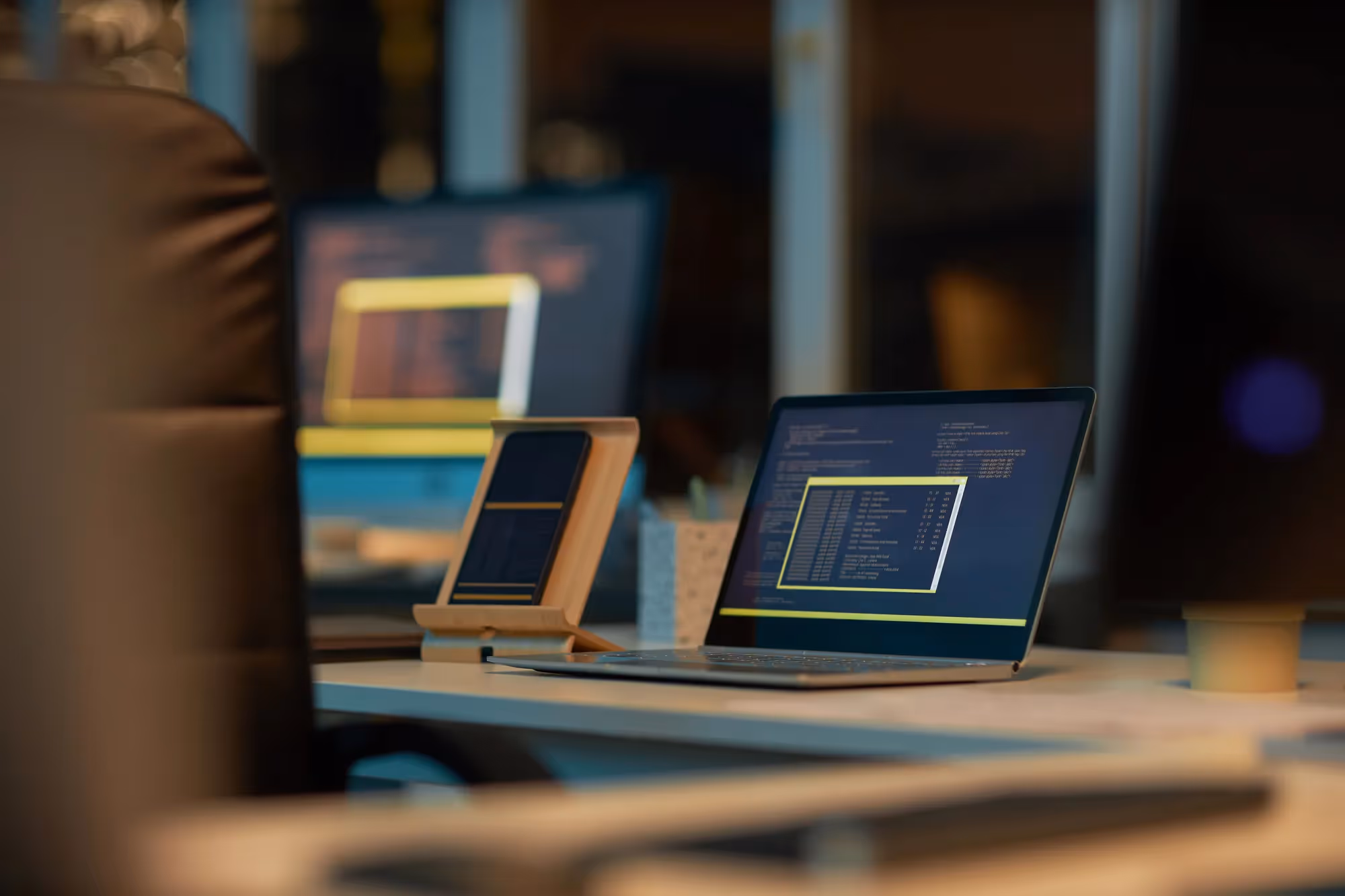 A laptop with a yellow screen sitting on a desk.