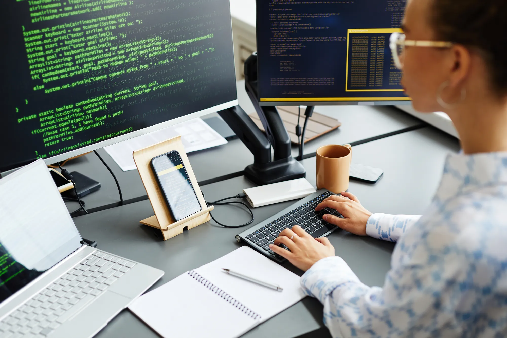 A person is typing on a keyboard in front of a computer monitor.
