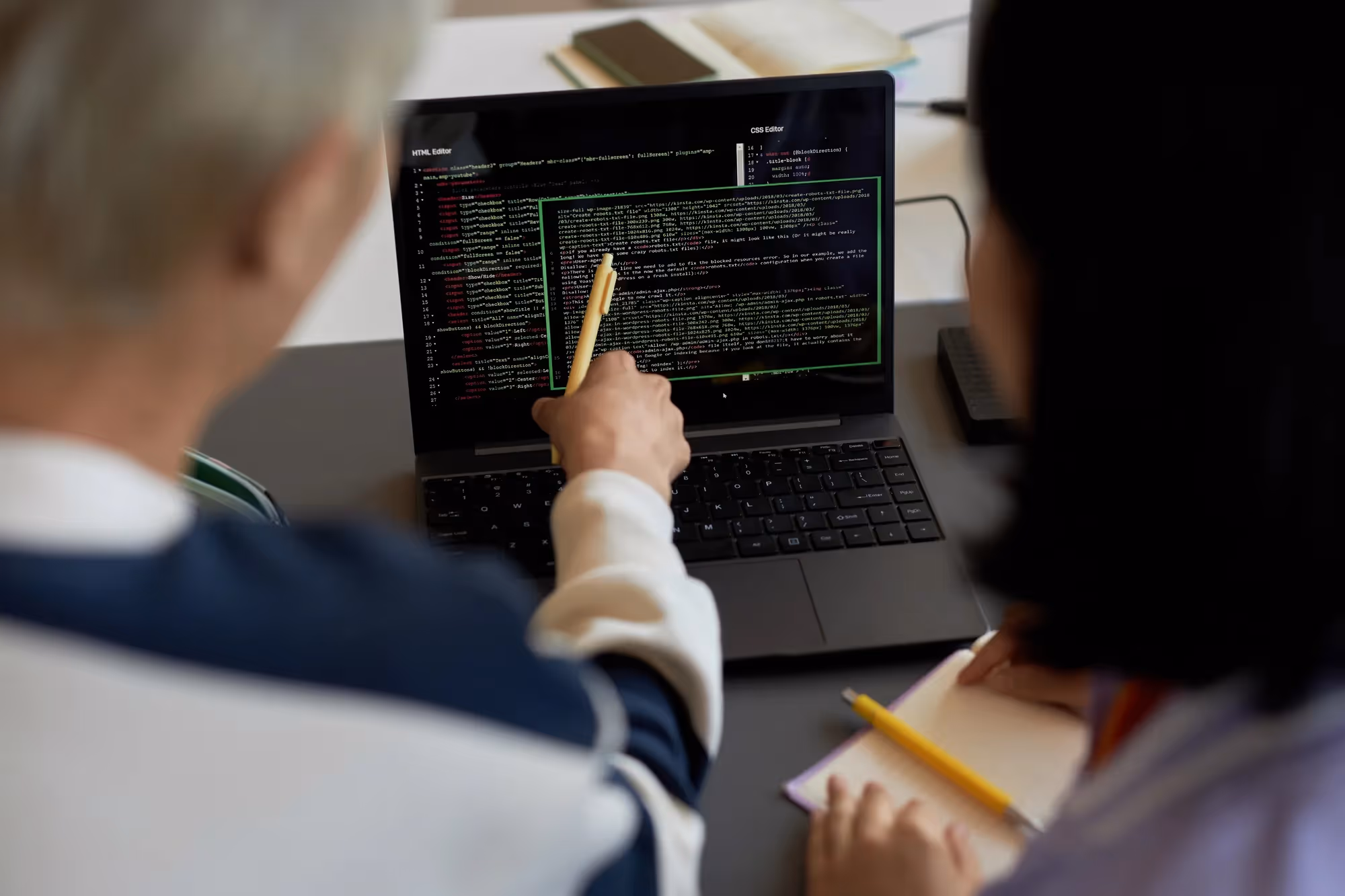A man and woman are looking at a laptop screen.