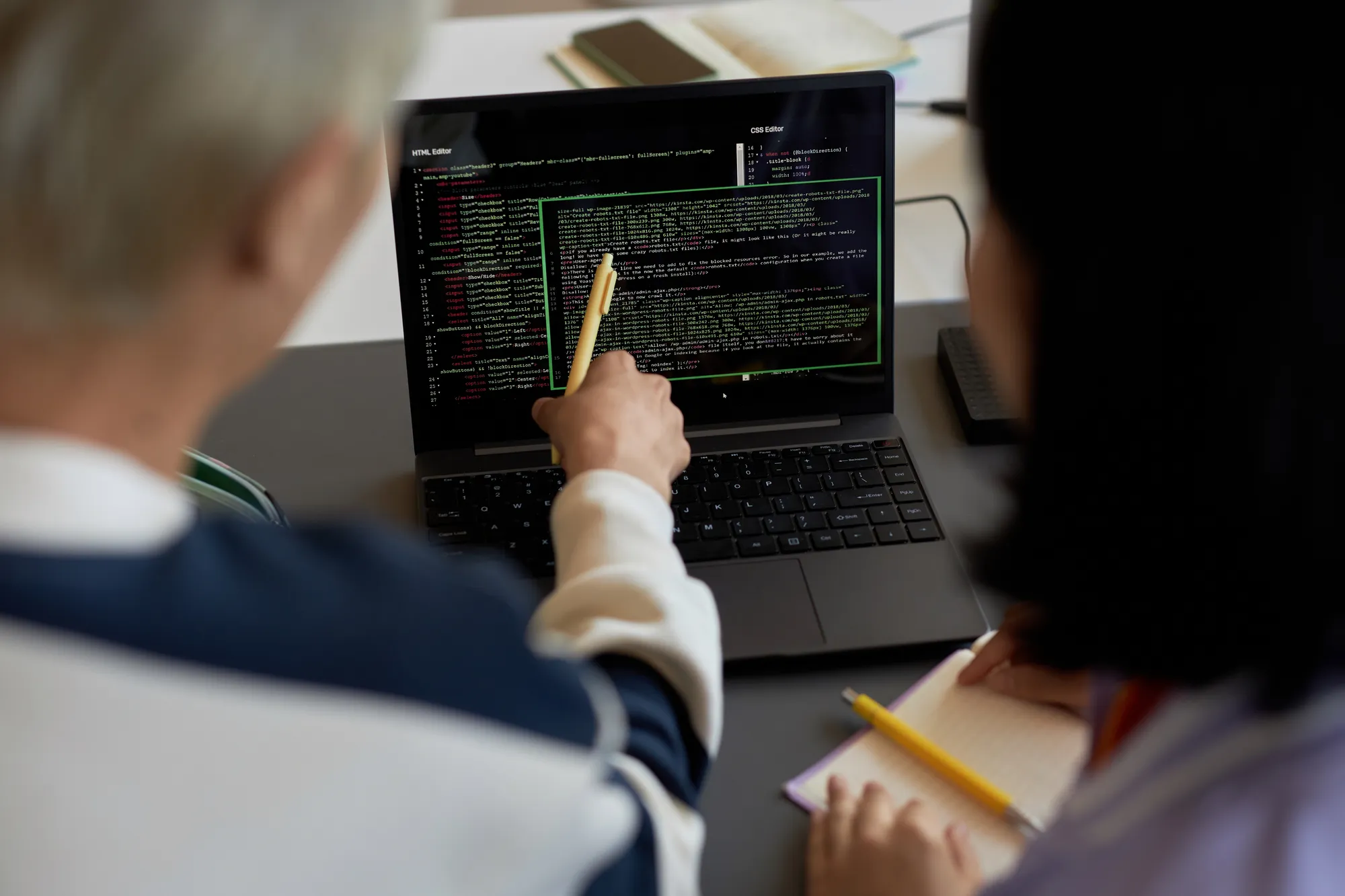 A man and woman are looking at a laptop screen.