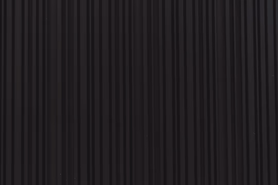 a close up of a black wall with vertical lines