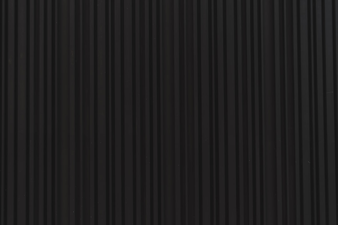 a close up of a black wall with vertical lines