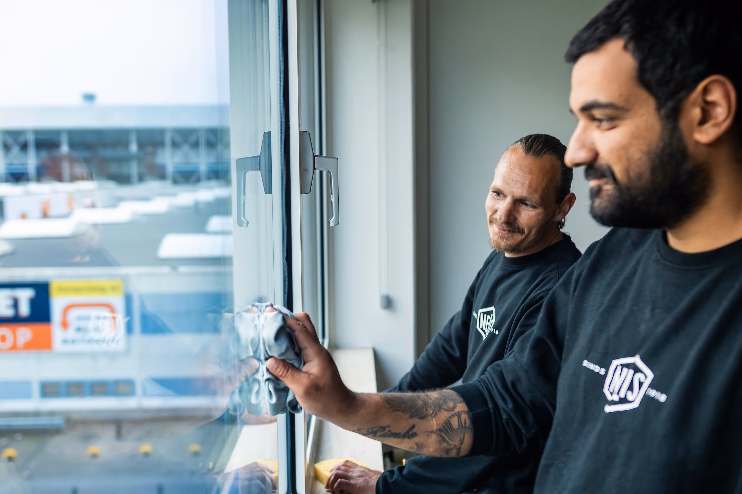 Twee schoonmakers van Nelis Company, een bedrijf dat social return invult met facilitaire diensten op maat.