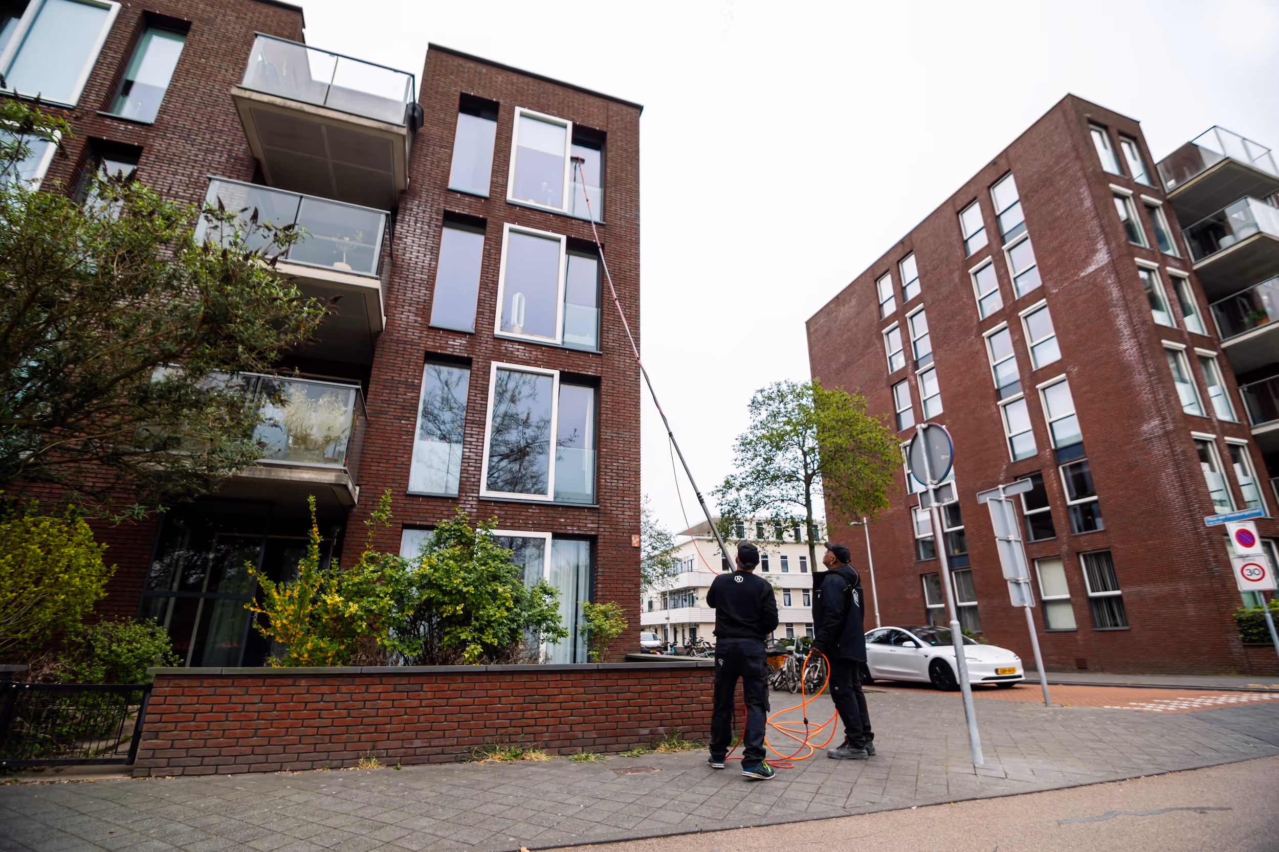 Twee glazenwassers van Nelis Company, een bedrijf dat social return invult met facilitaire diensten op maat.