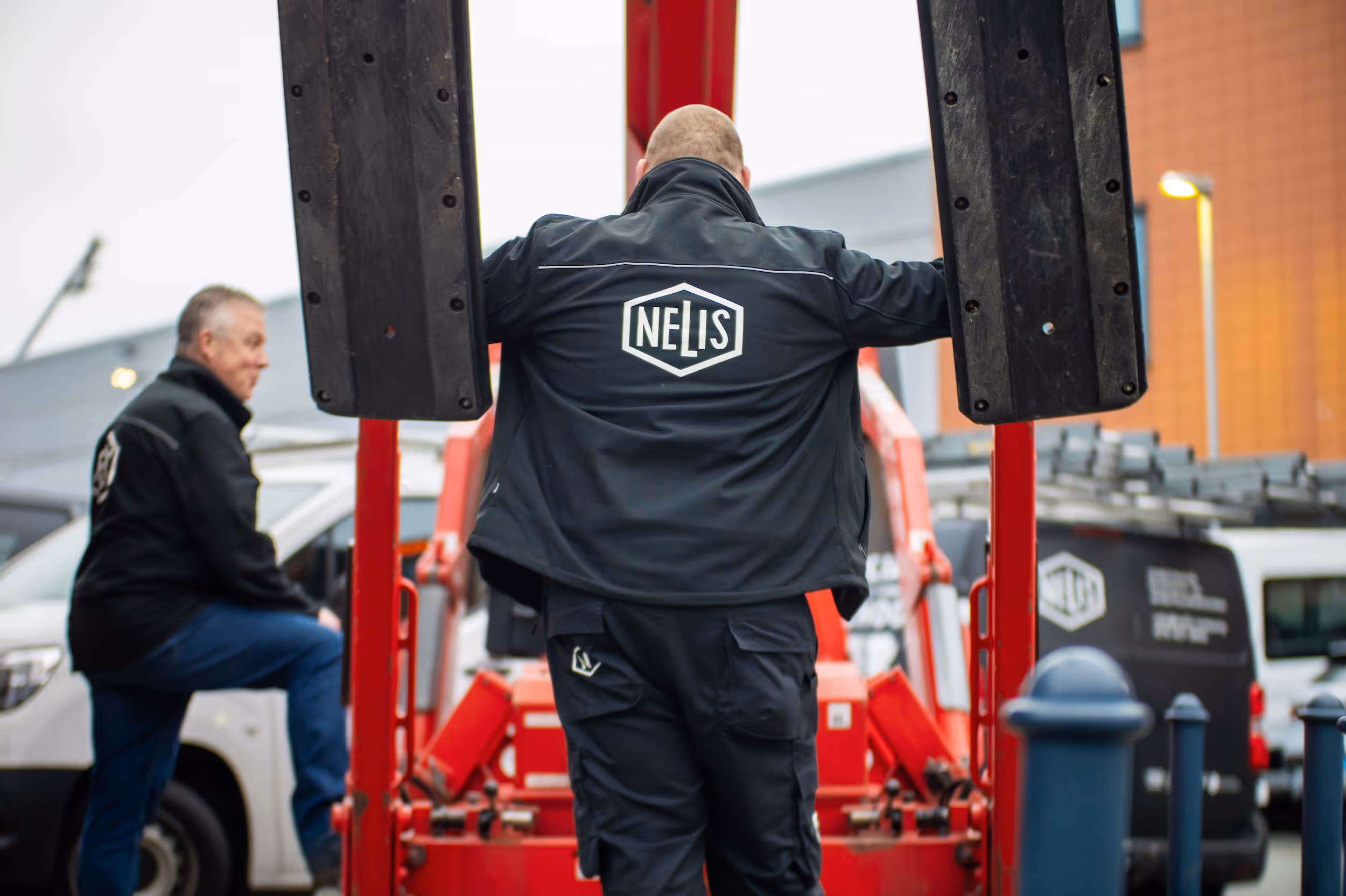Twee medewerkers van Nelis Company, een bedrijf dat social return invult met facilitaire diensten op maat, bij een hoogwerker.