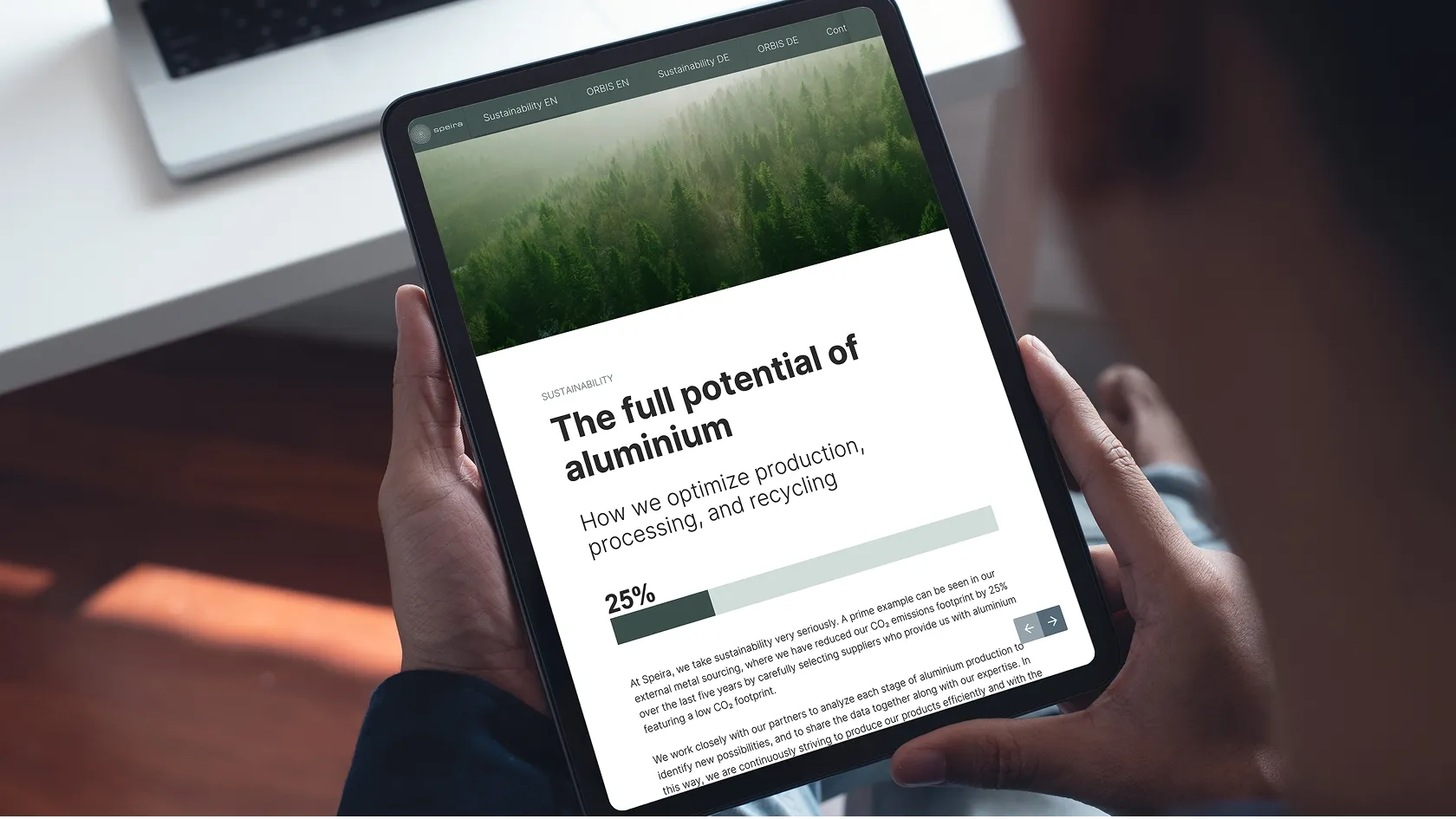 Person holds a tablet that displays a web page about optimising aluminum production, processing and recycling with the headline “The full potential of aluminum.”