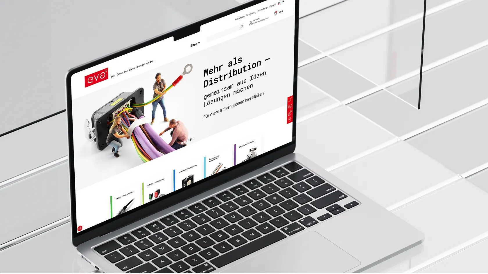 Laptop shows EVO's website with miniature figures holding colorful cables in an electrical connection.