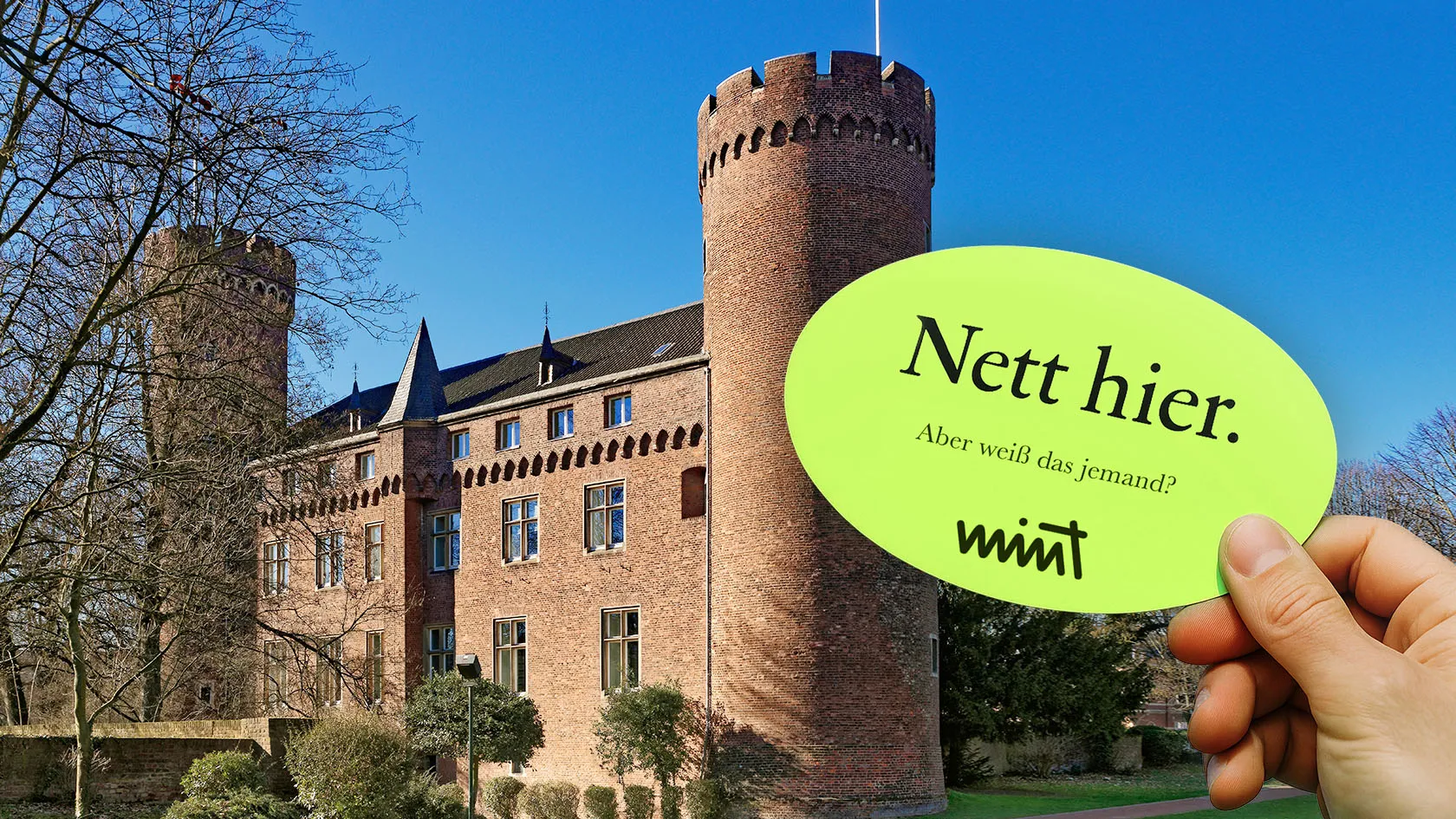 Bild der Burg Kempen, davor eine Hand die einen Sticker hält auf dem steht "Nett hier. Aber weiß das jemand?" MINT
