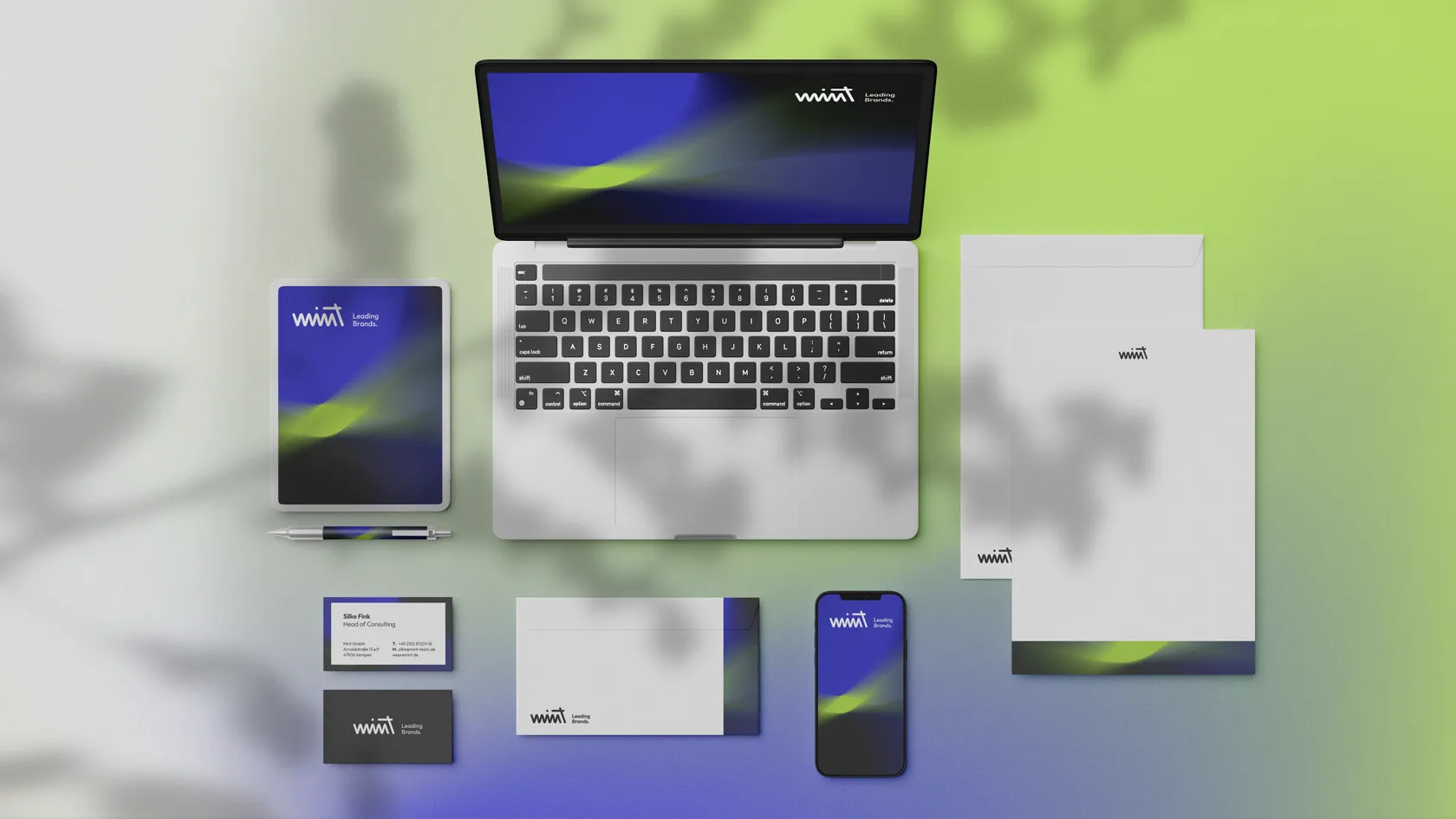 Marken-Branding-Layout mit Laptop, Tablet, Smartphone, Visitenkarte, Stift, Umschlägen und Briefpapier auf grün-blauem Hintergrund.