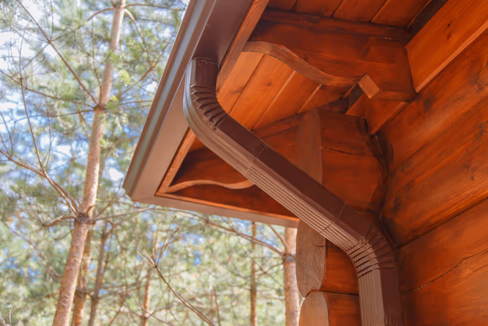 A wooden structure with a brown roof and a pipe coming out of it.