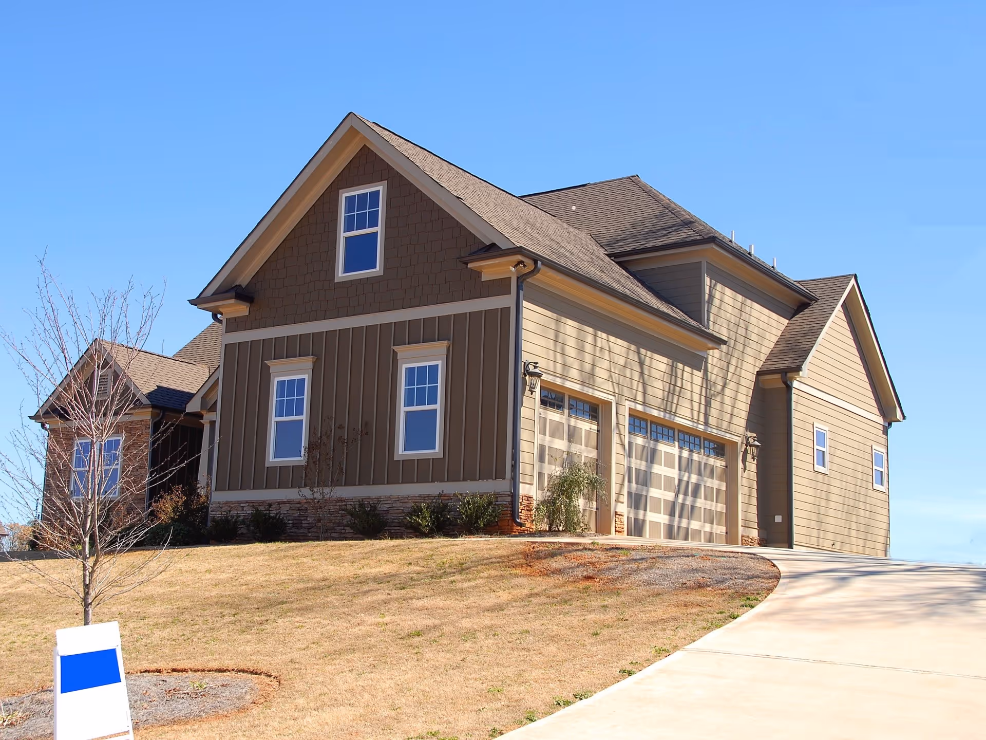 A house with a brown roof and a white garage door.
